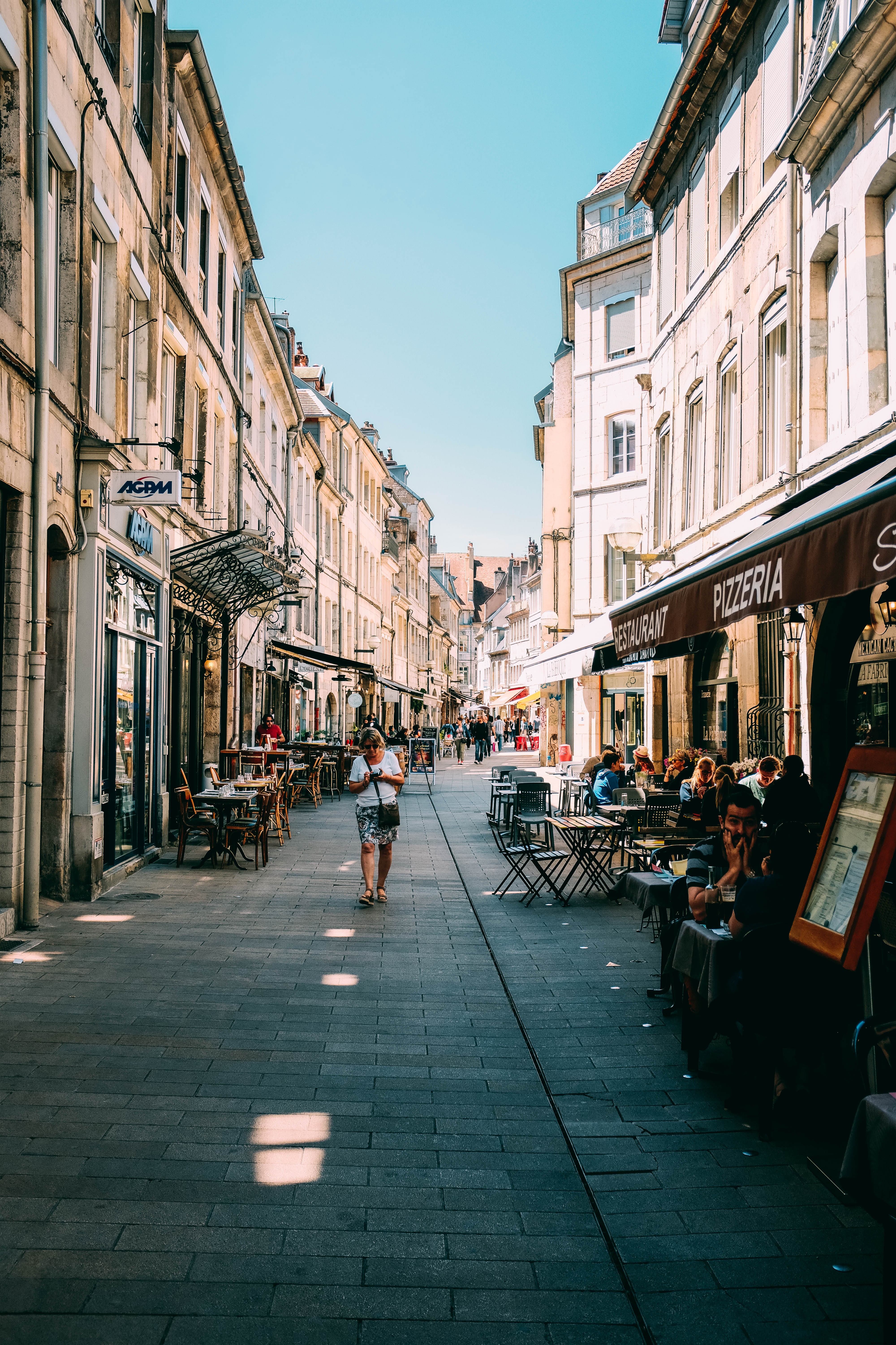 Los turistas se sientan fuera de una pizzería en una foto de una calle europea