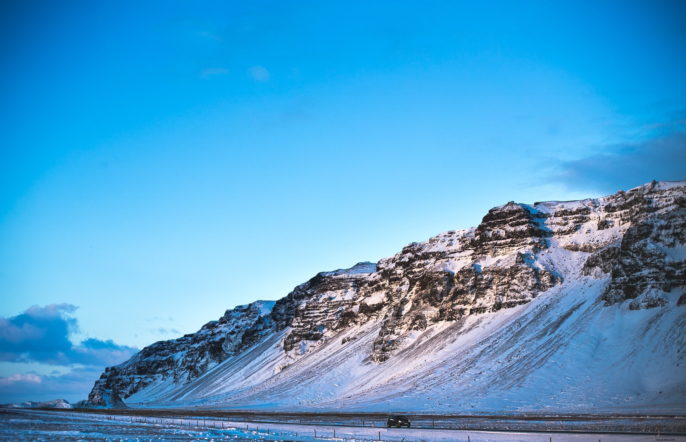 コンパクトカーがアイスランドの丘を通り過ぎる写真