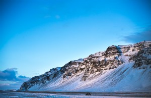 コンパクトカーがアイスランドの丘を通り過ぎる写真