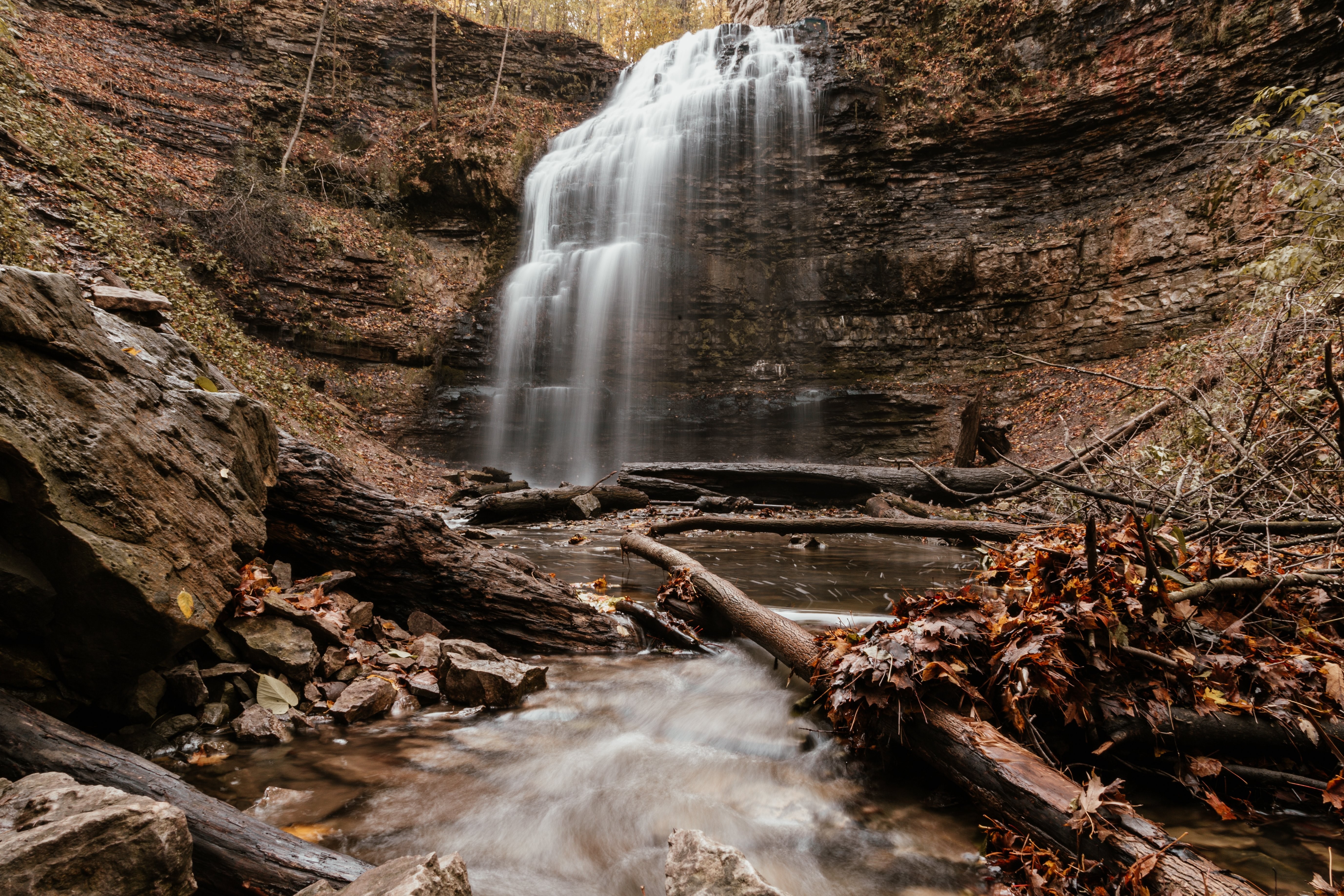 Foto de cachoeira sobre folhas de outono