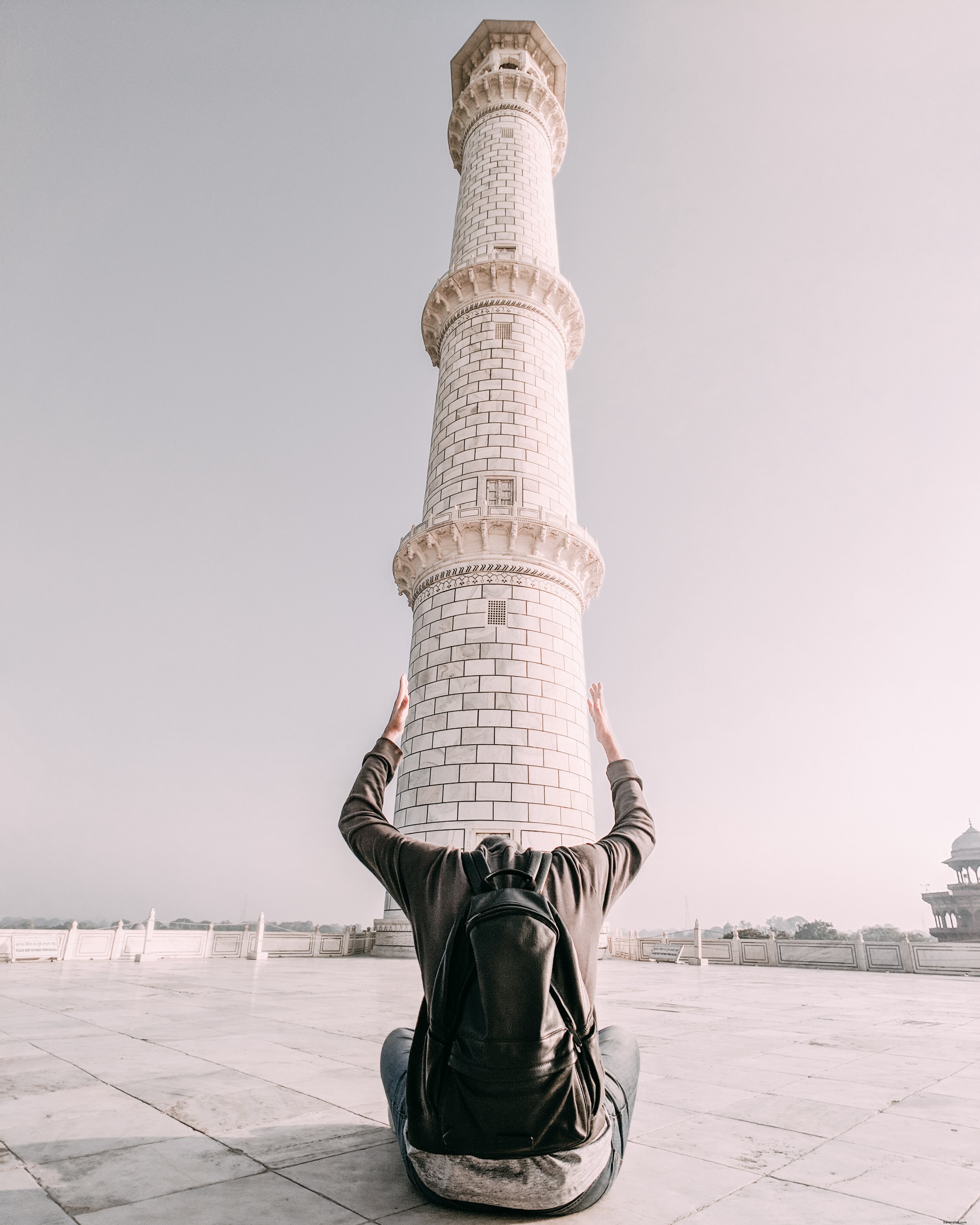Un homme encadre la base d une tour avec ses bras Photo