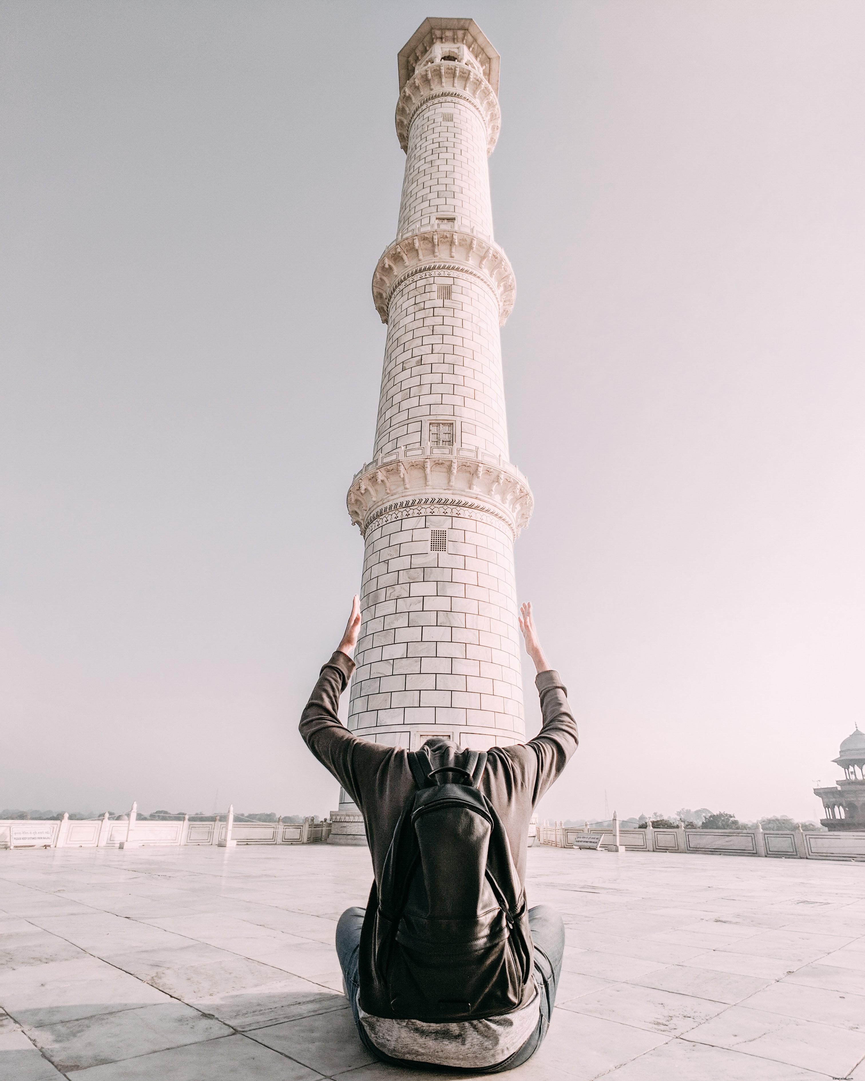 Un hombre enmarca la base de una torre con sus brazos Foto