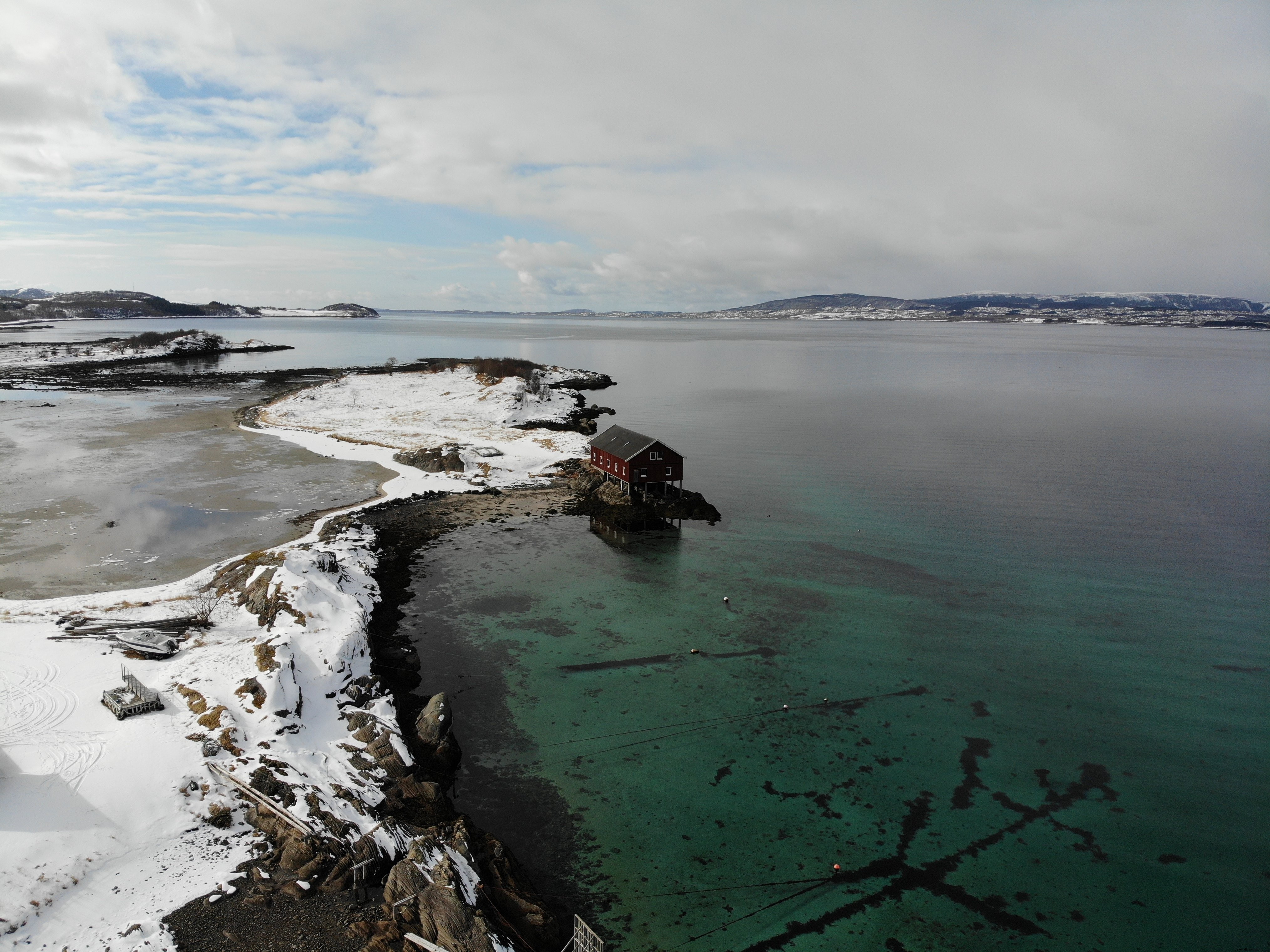 Foto de uma única casa na água com vista para uma paisagem congelada