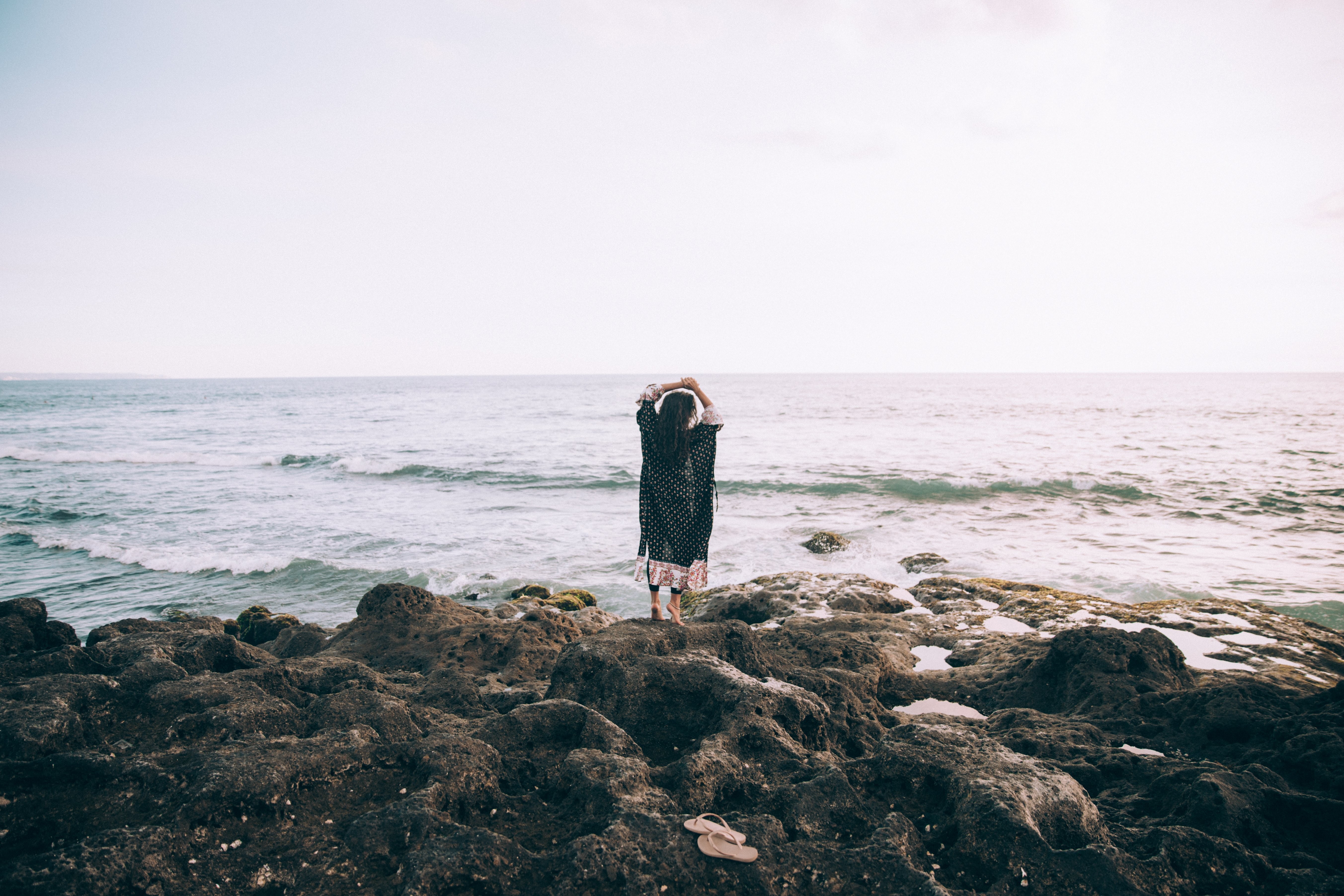 ビーチのそばの女性が空想の写真に手をかざす