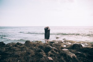 Una donna sulla spiaggia alza le mani in fantasticherie foto