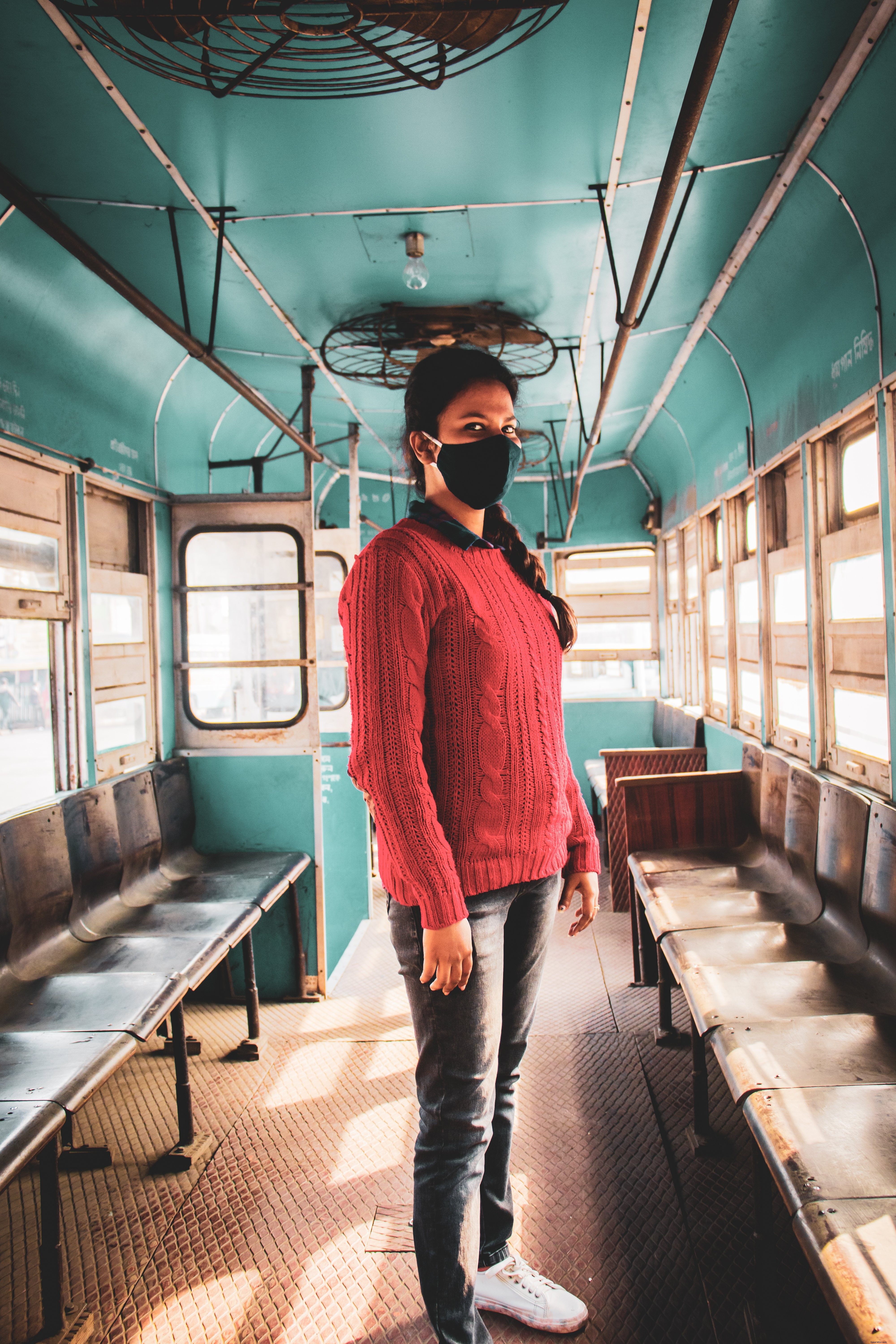 Persona con mascarilla negra en una foto de autobús azul