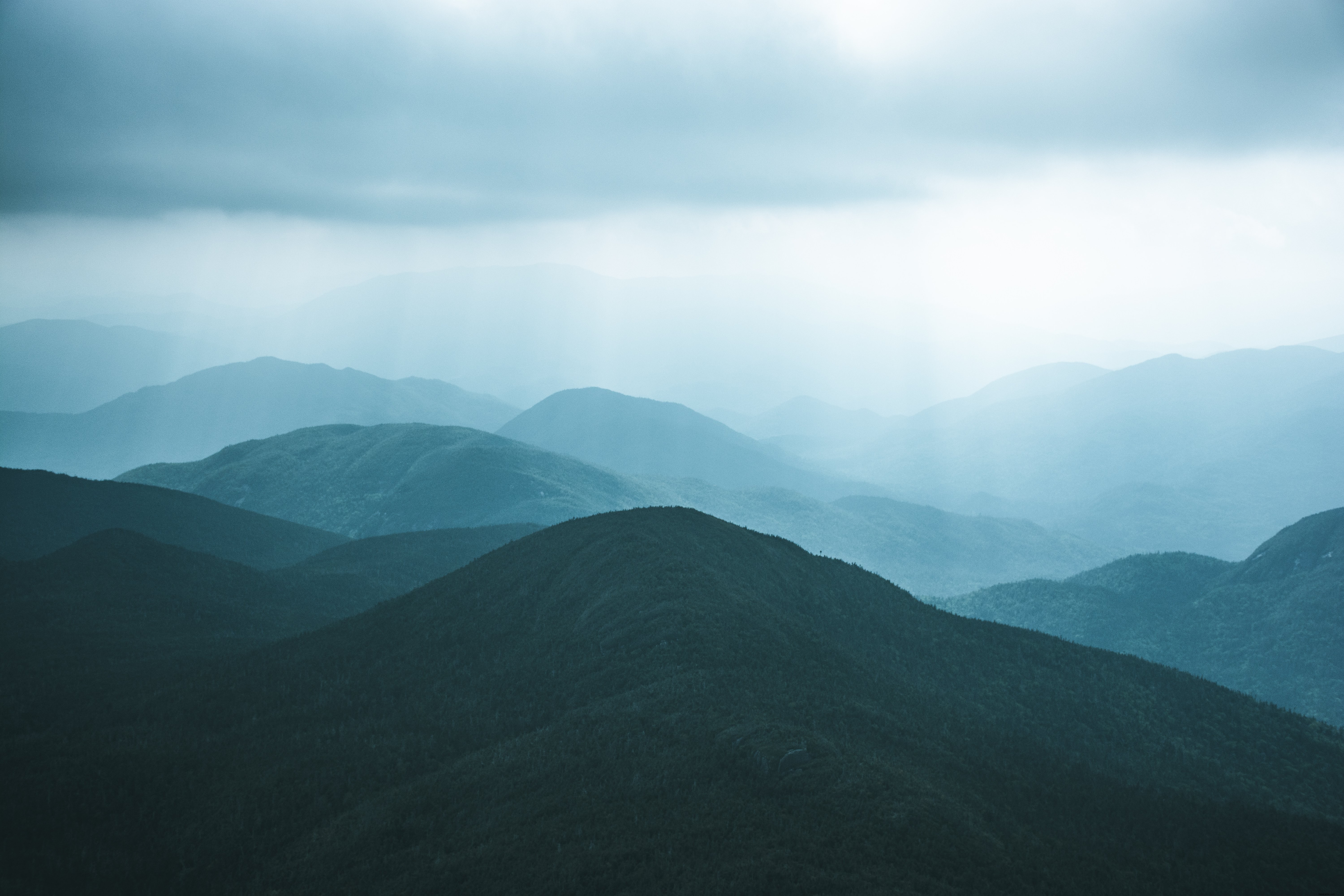 Colinas cubiertas de árboles contra un cielo gris Foto