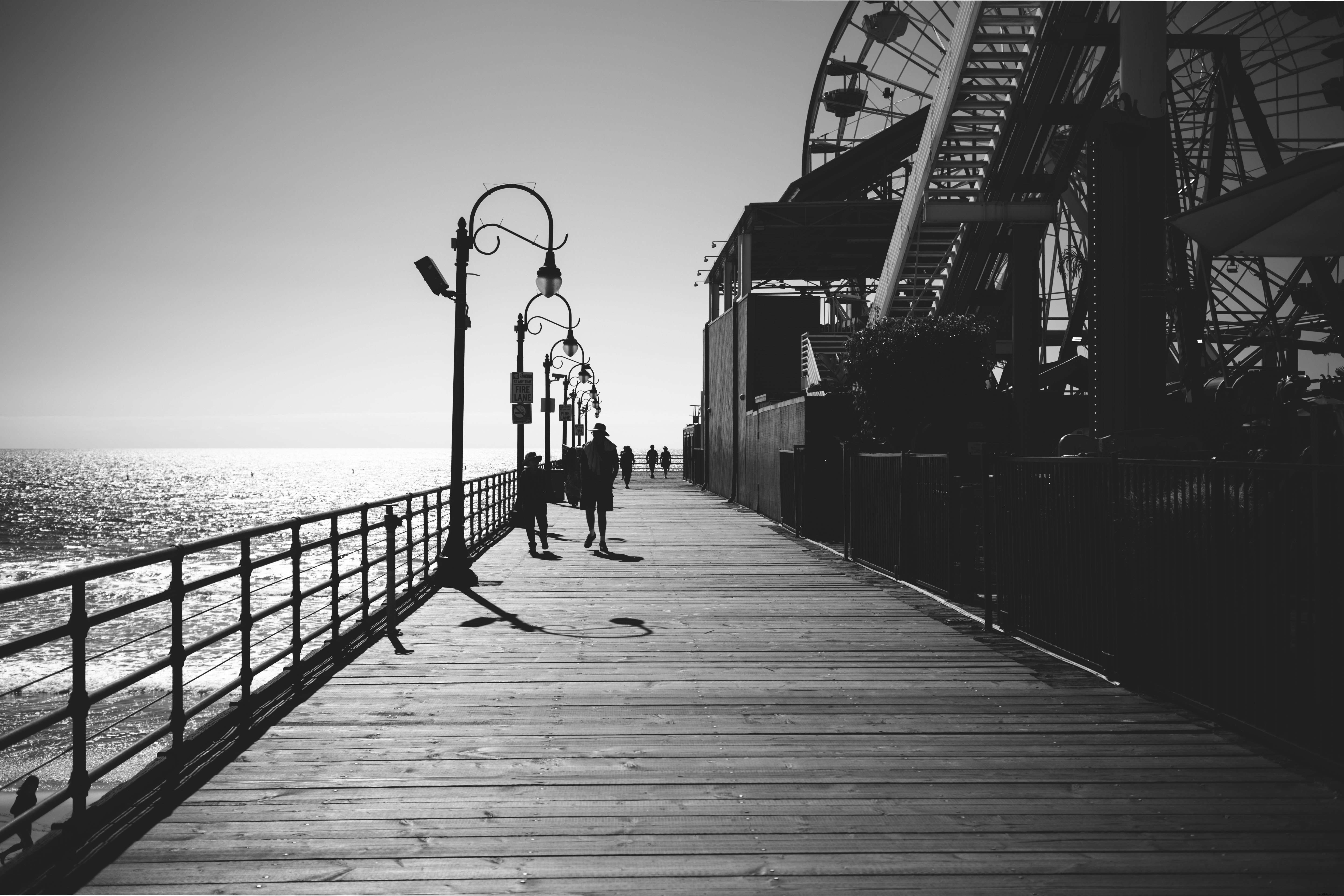 遊歩道の写真に沿って歩く白黒画像