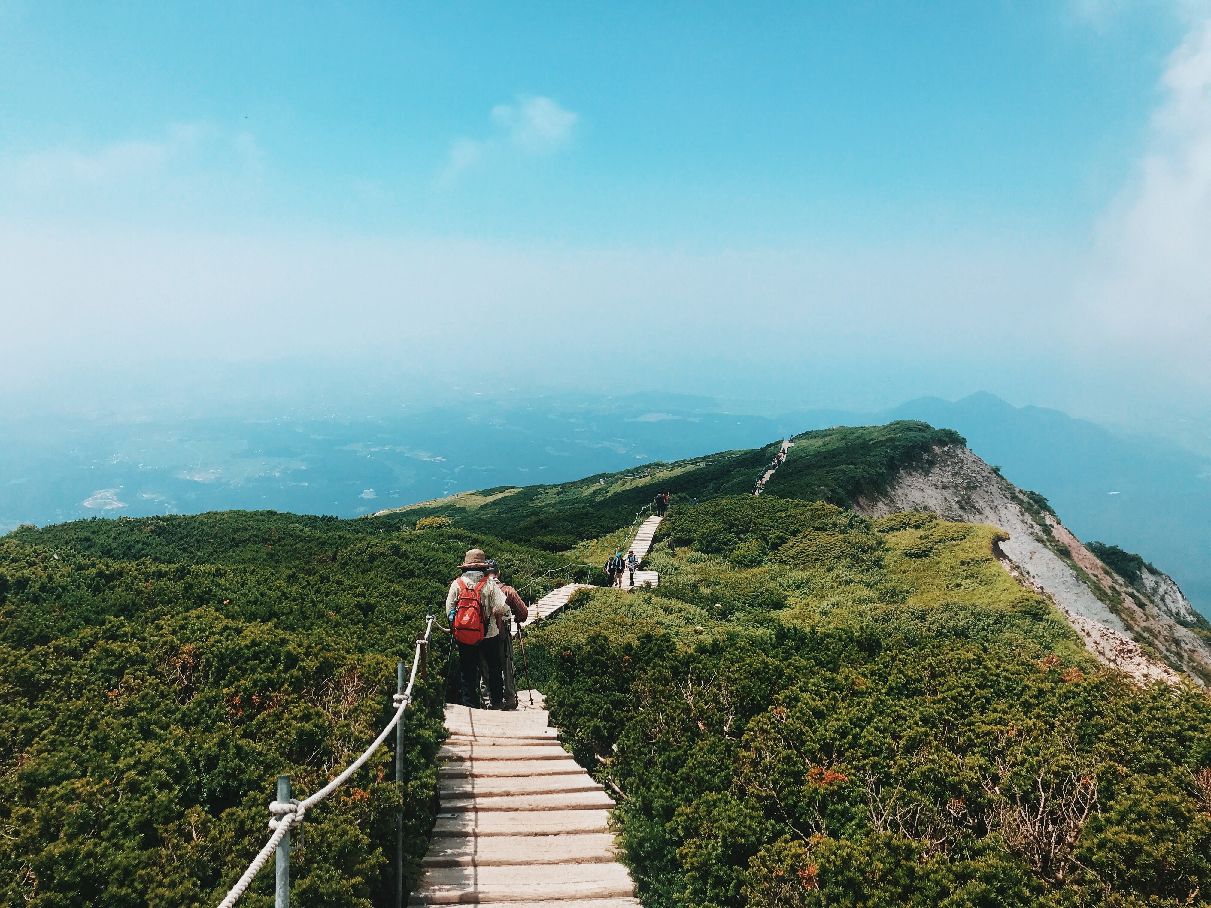 山を渡って歩くハイカー写真