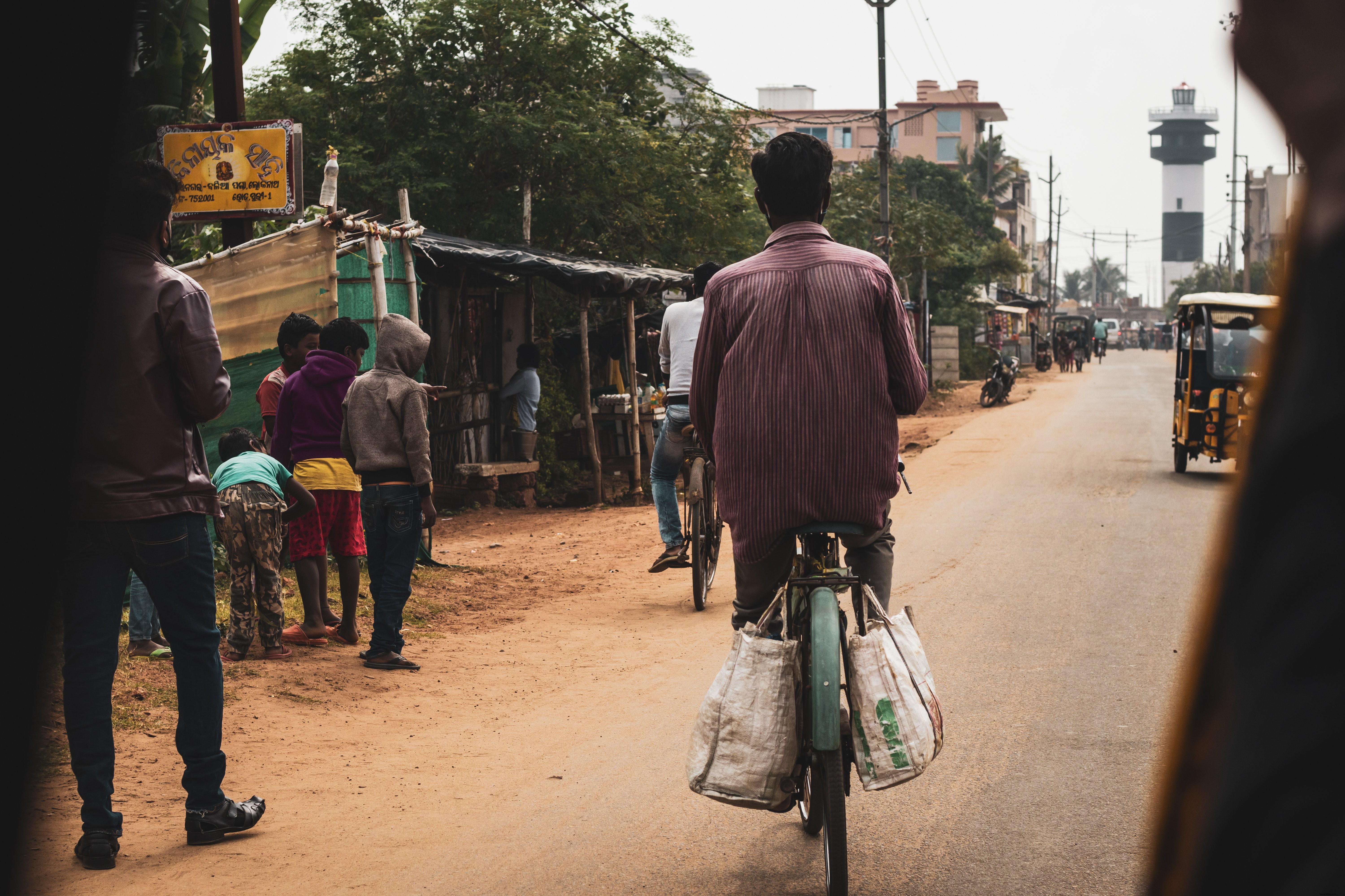 Foto Person Bikes Down A Dirt Town Road