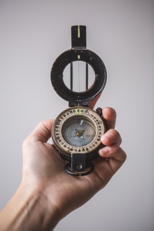 Close Up of Hand Holding Compass Photo