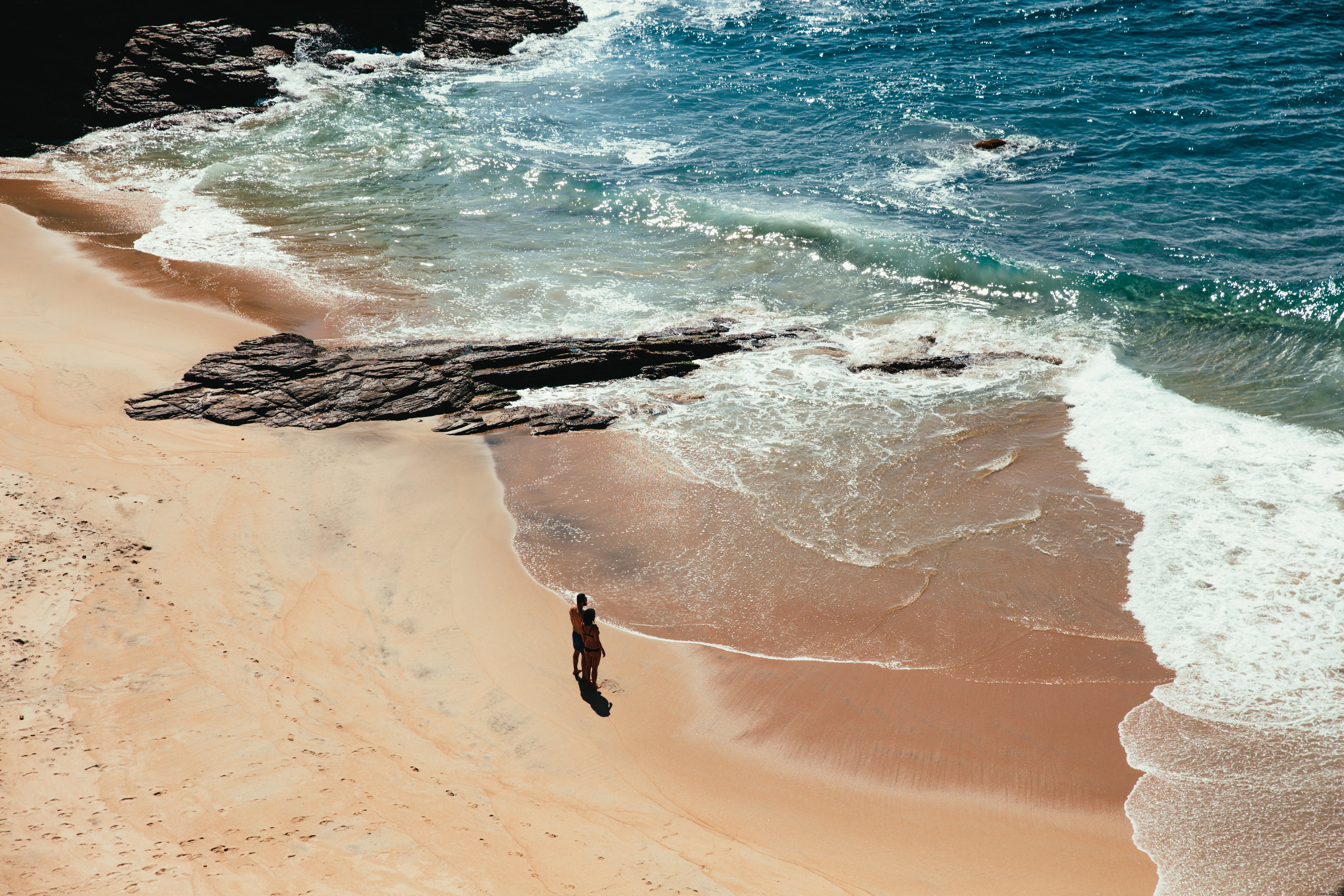 Foto de casal em pé na praia