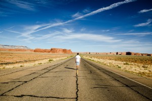Un hombre se encuentra en las marcas de la carretera de una foto de la autopista del desierto