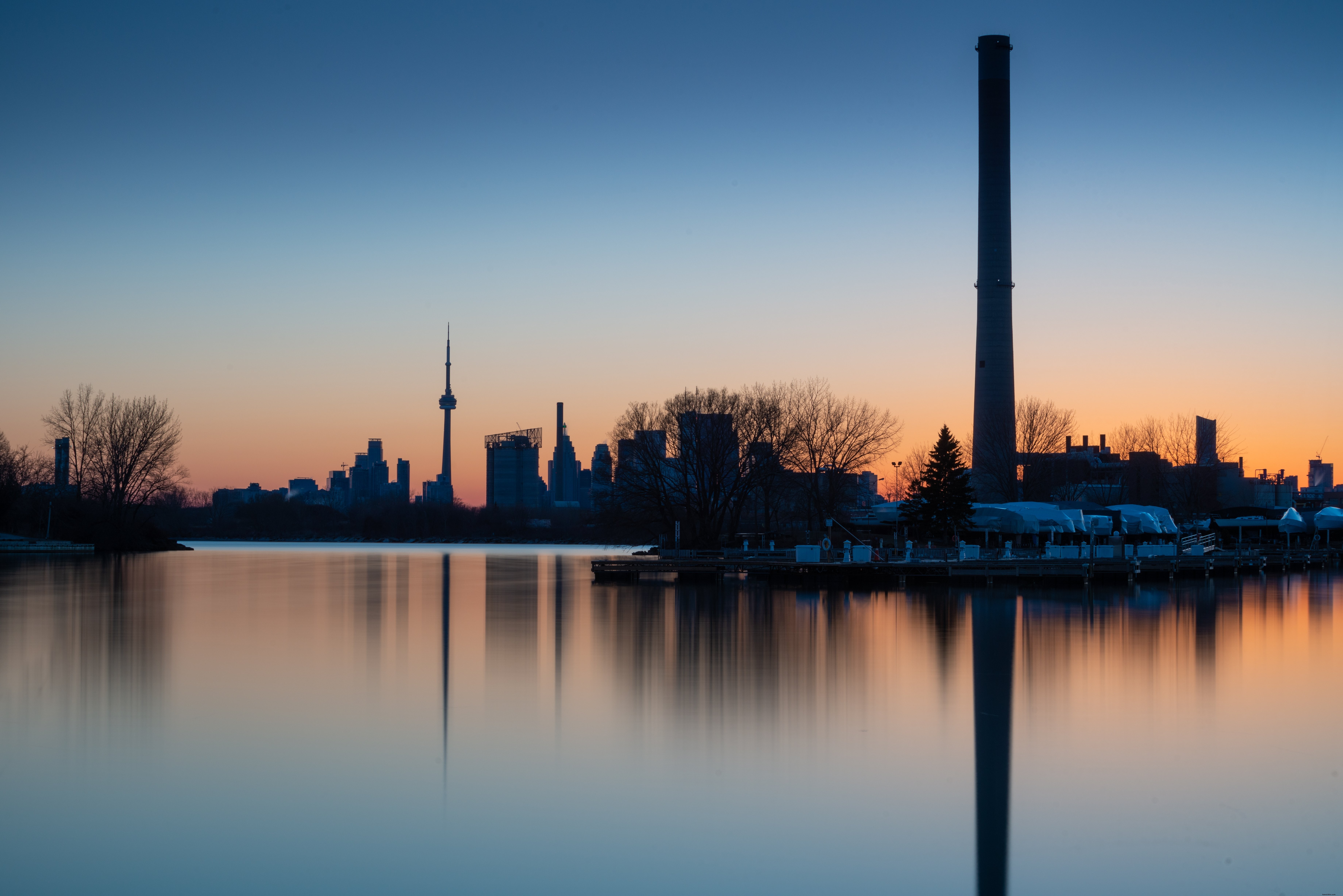 Foto do horizonte de Toronto ao pôr do sol refletindo na orla