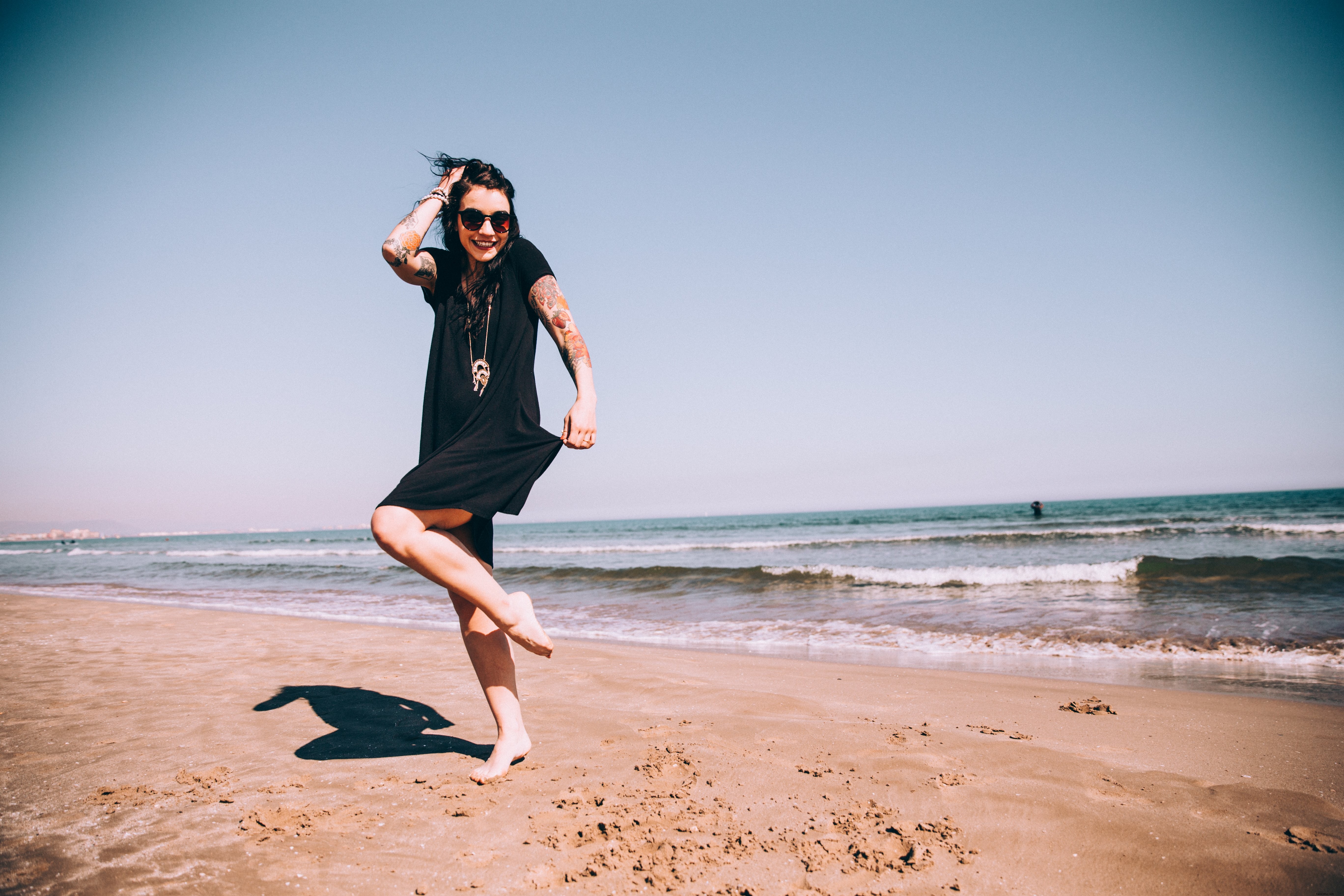 入れ墨の女性はビーチで太陽を楽しんでいます写真