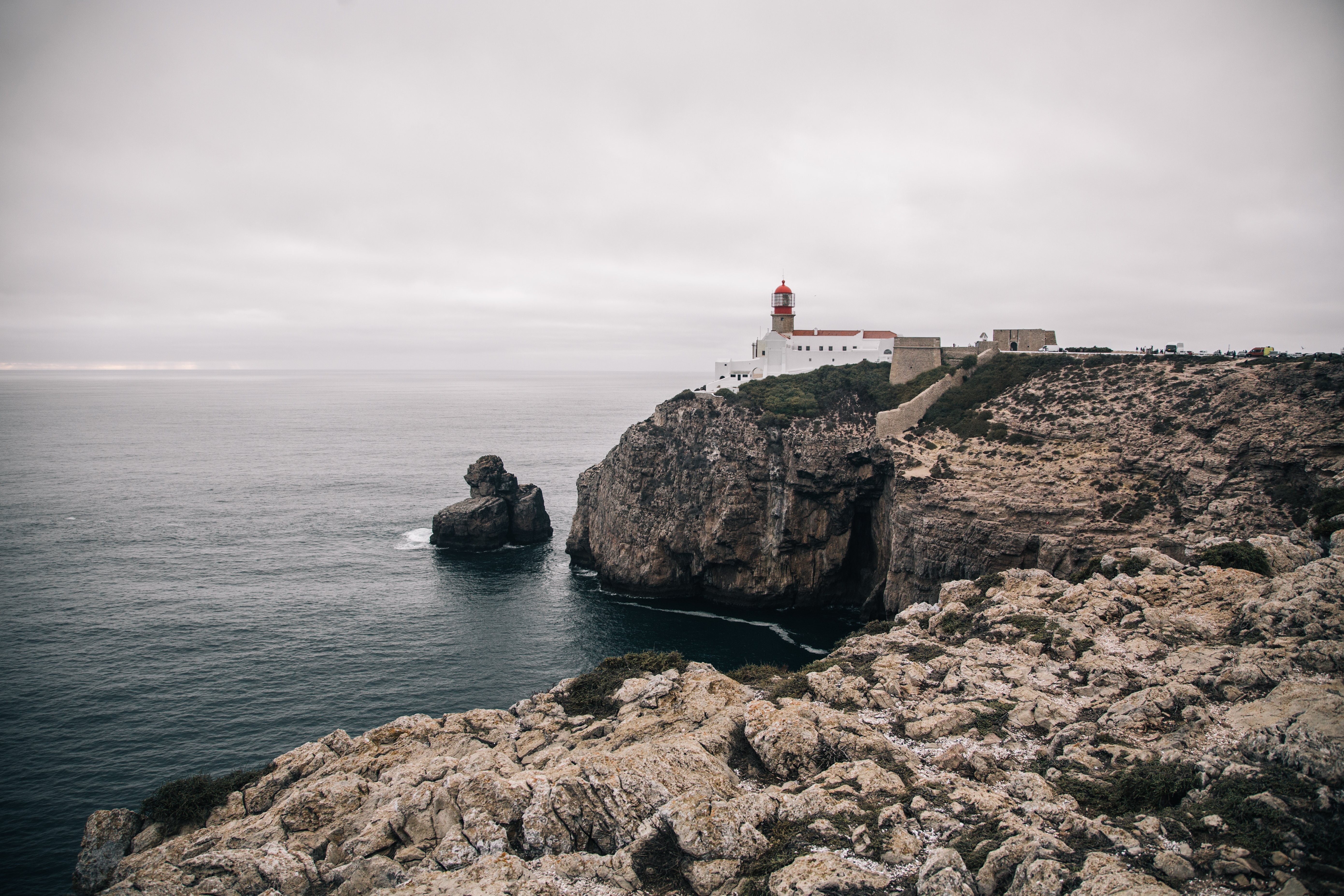 Un faro imbiancato si erge su una scogliera scoscesa Foto