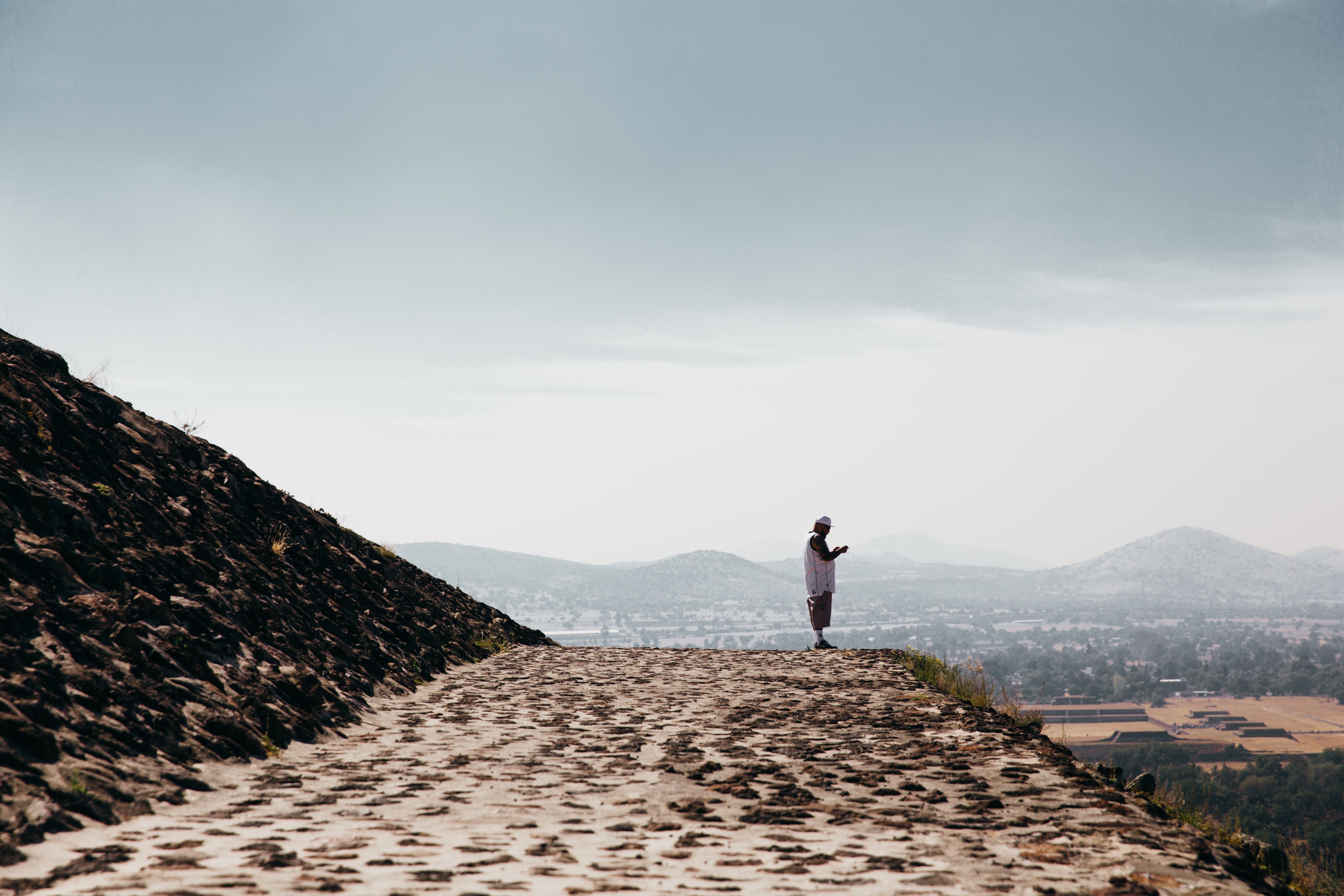 Foto de homem ora na borda do templo de pedra