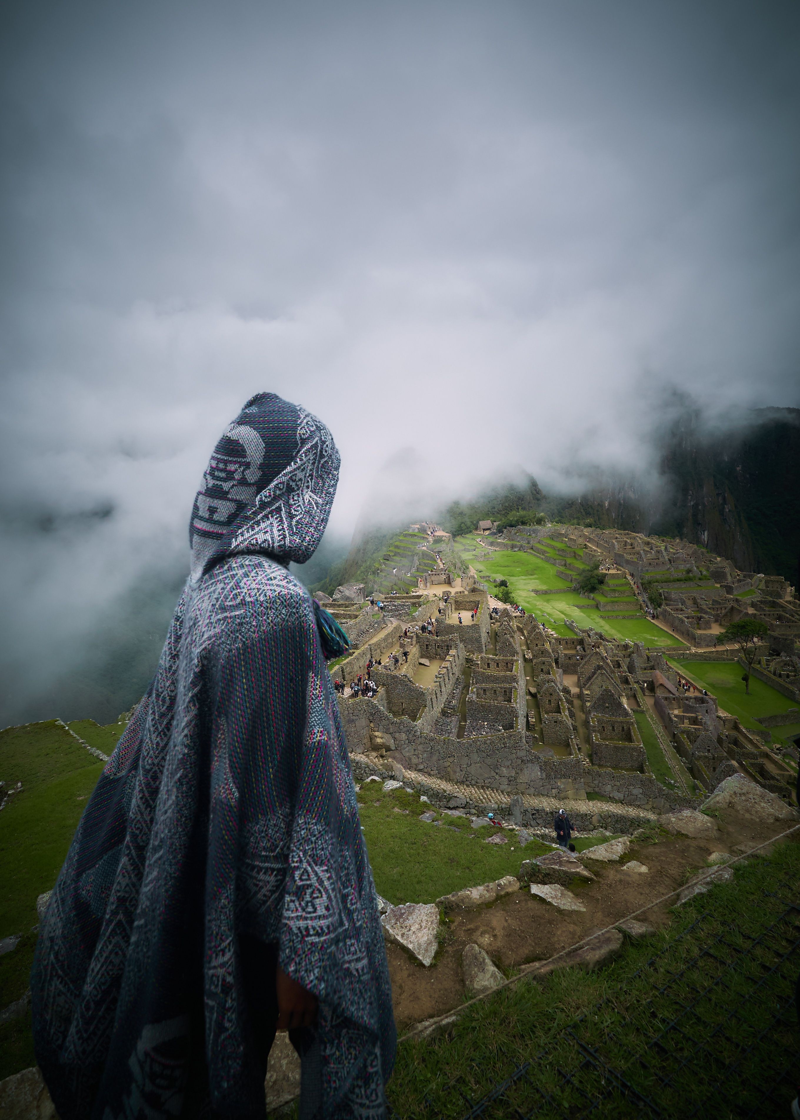 Persona incappucciata che si affaccia sulle rovine foto