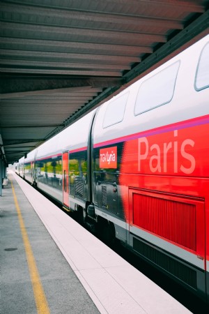 Foto de um trem vermelho com destino a Paris em uma plataforma