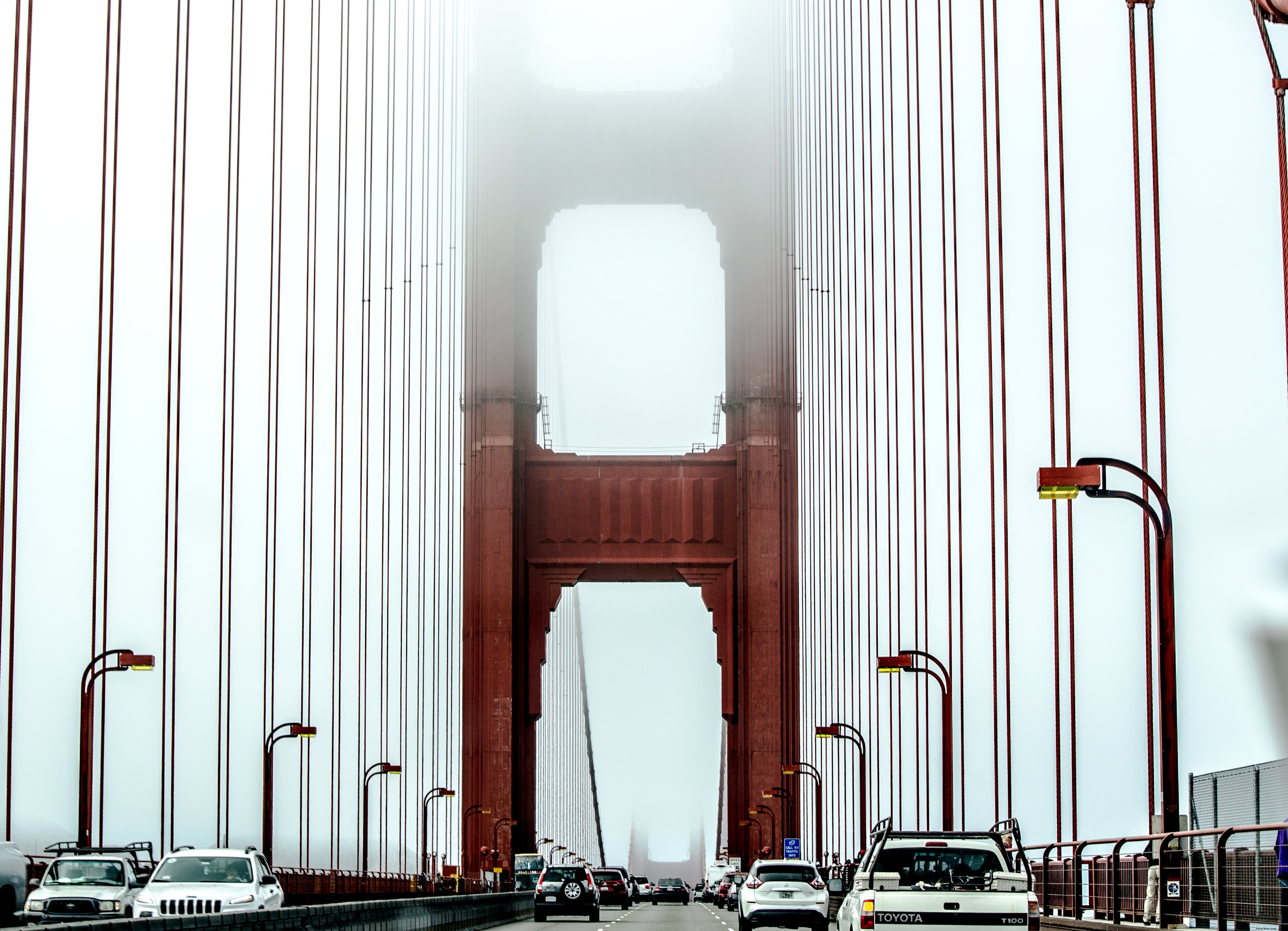 Tráfico en un puente colgante suspendido en la foto de la niebla