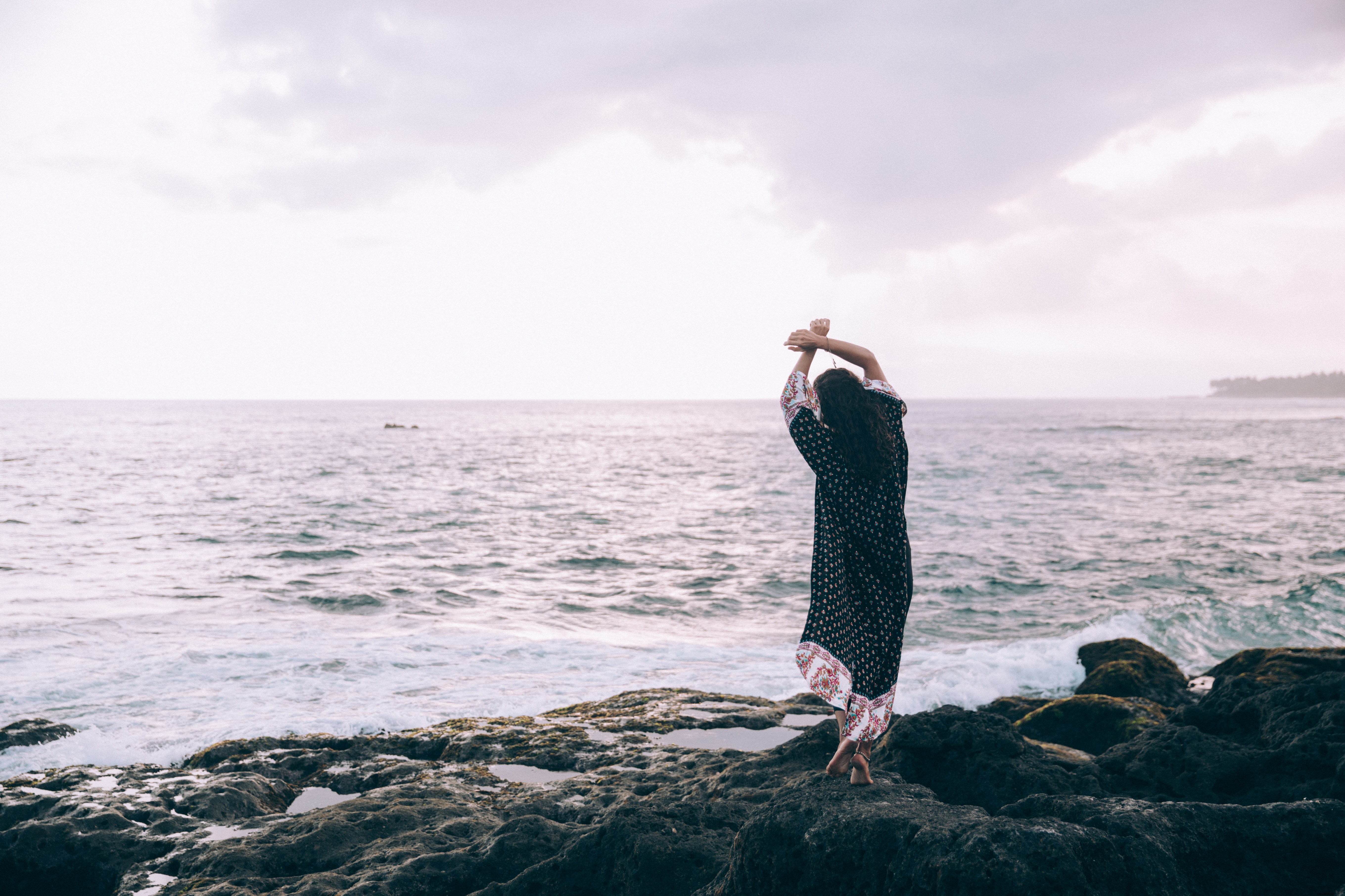 Una donna in un accappatoio da spiaggia posa sulla spiaggia foto