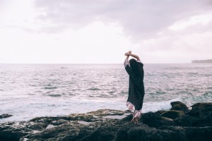 Uma mulher com uma túnica de praia posa na praia foto