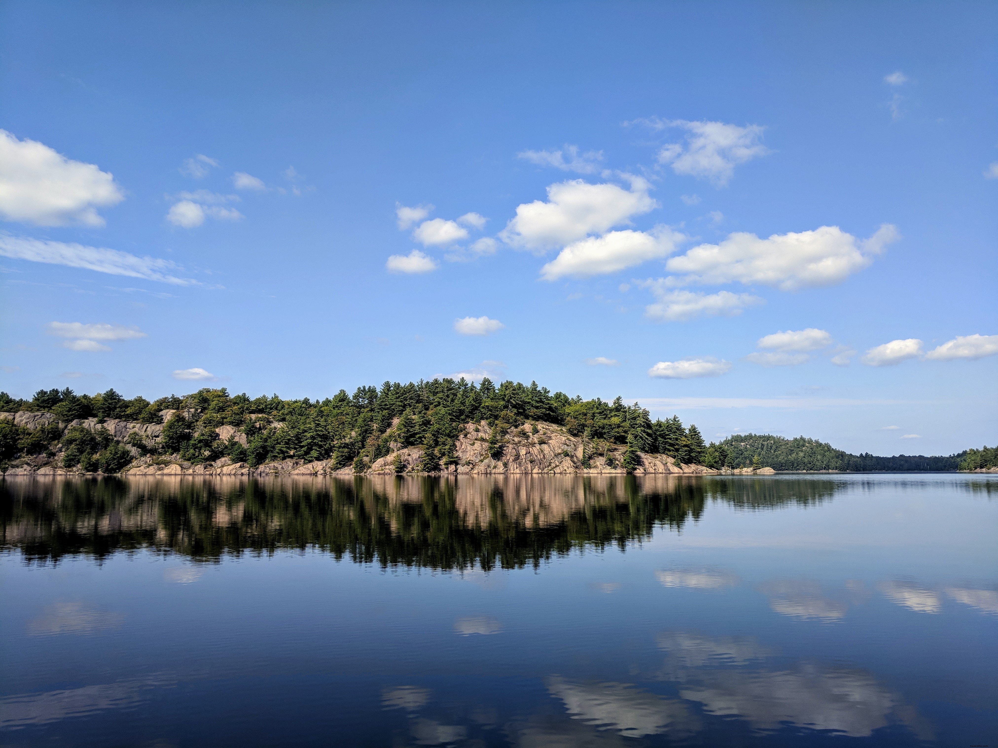 Reflejo de rocas y árboles en el lago Foto