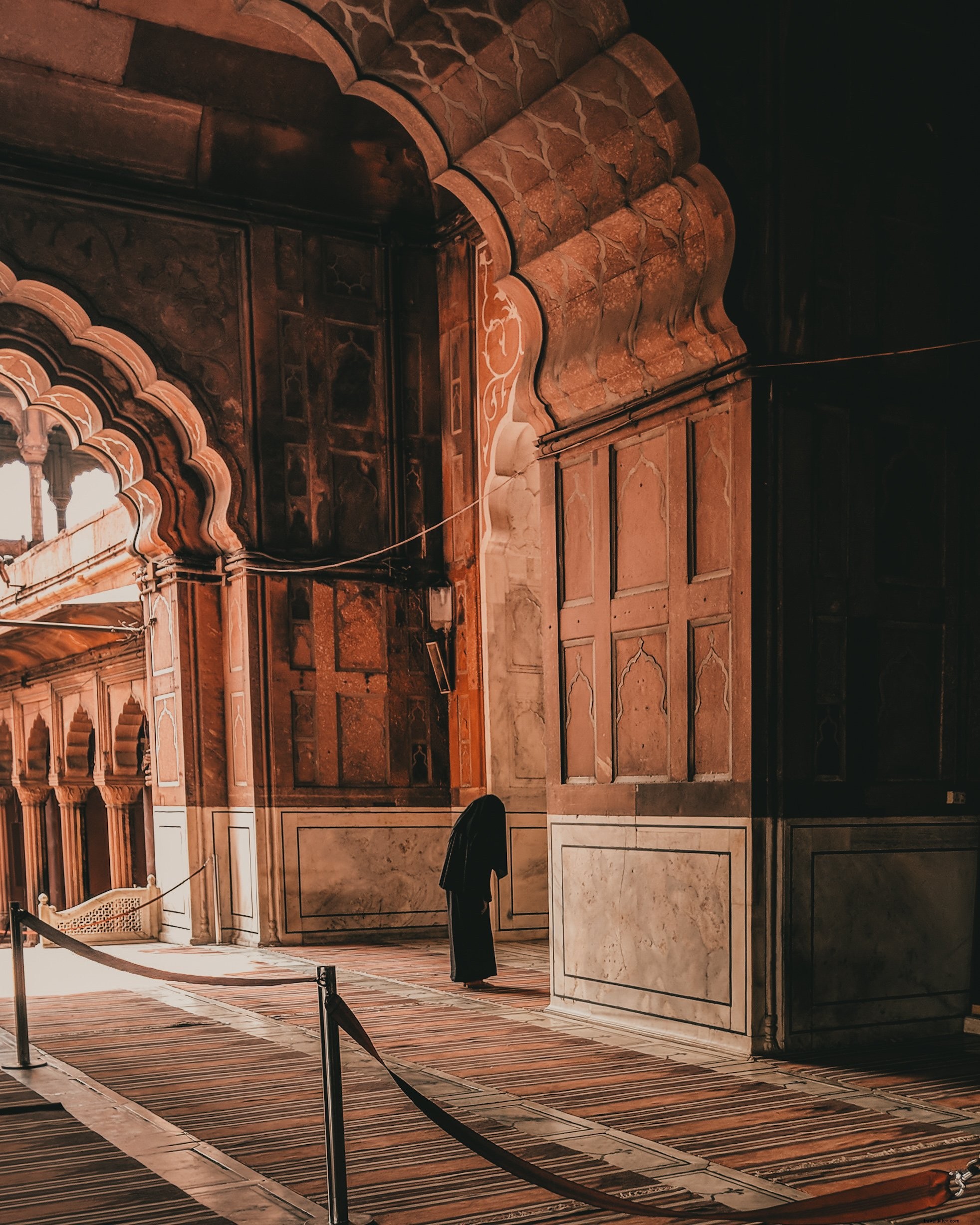 Una figura vestita cammina attraverso gli archi Photo