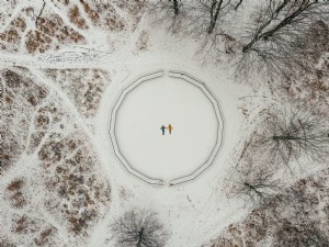 木々に囲まれた2人のスノーエンジェルの空撮写真