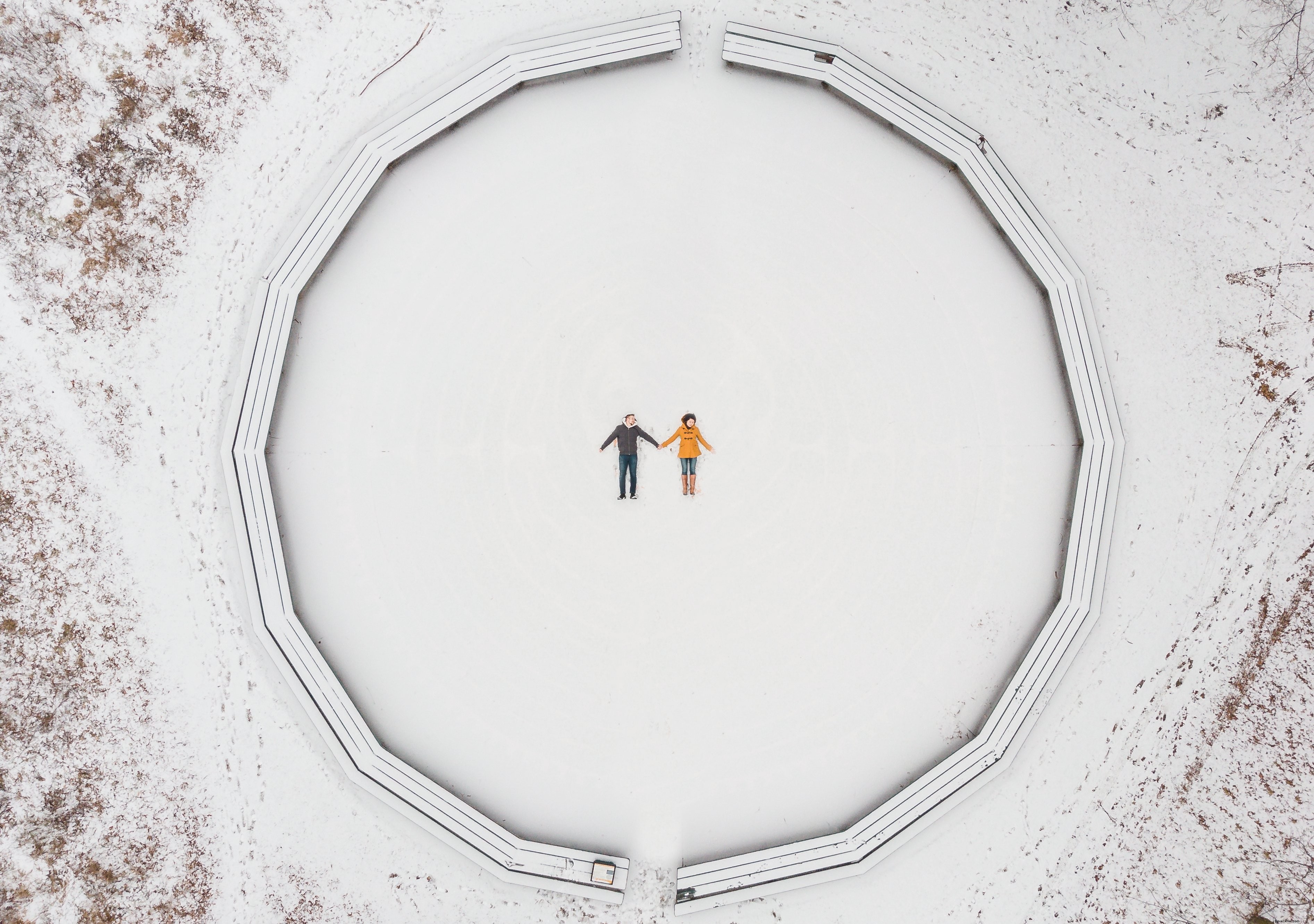 Veduta aerea di una coppia che fa foto di angeli di neve