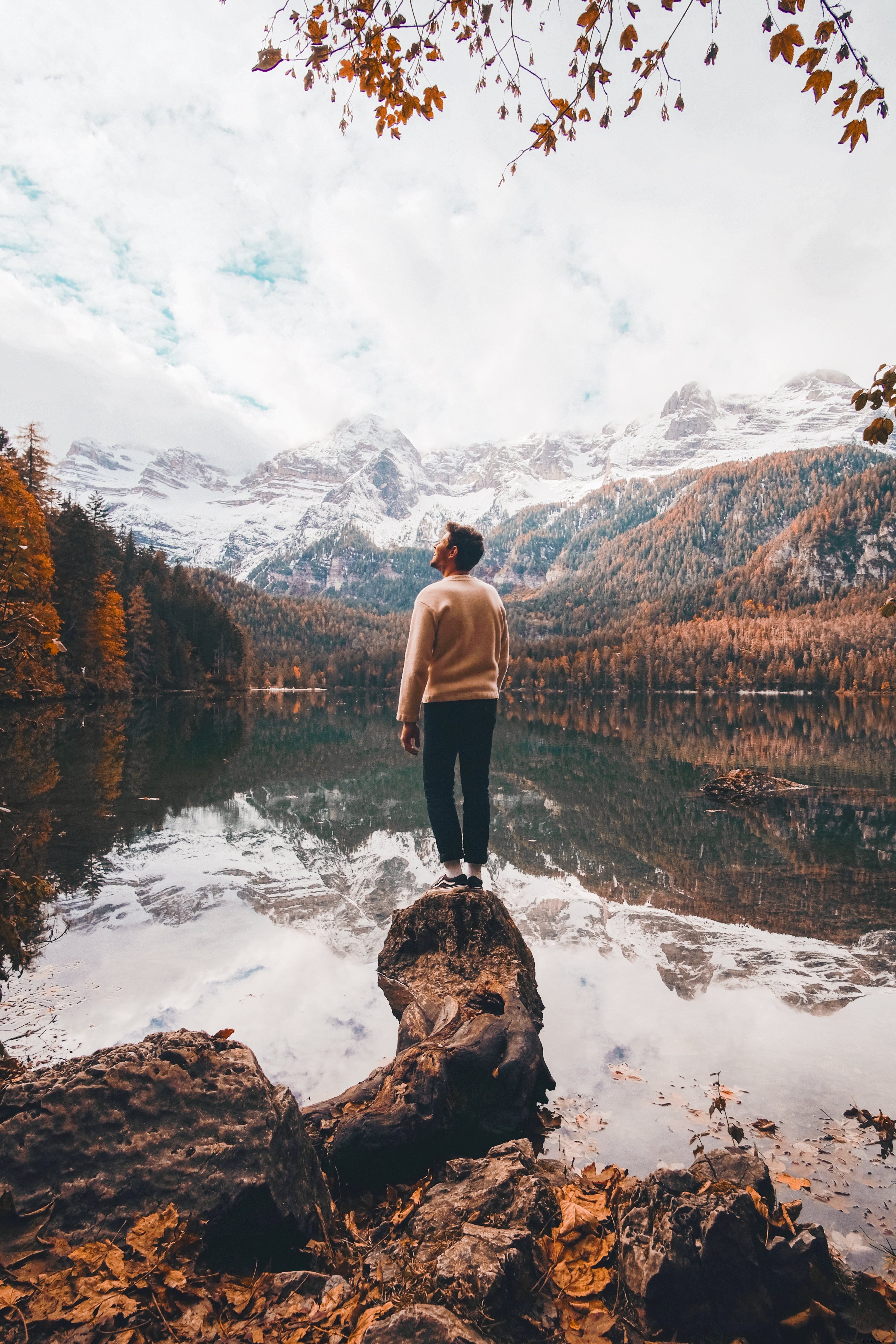 Persona mira hacia las montañas blancas en la foto de otoño