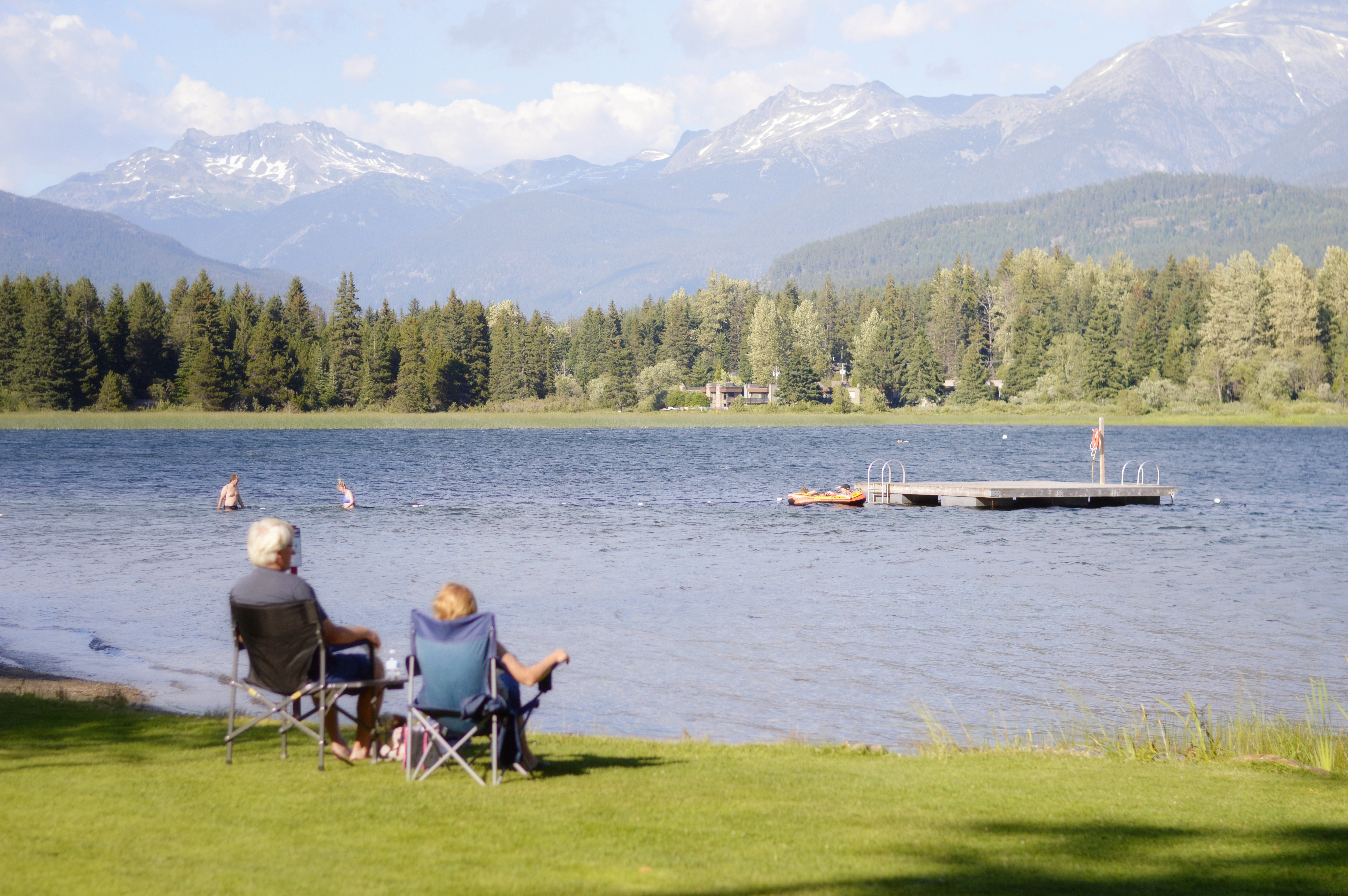 Pareja sentada junto al lago y disfrutar de la foto de la vista