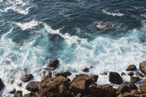 Le onde si infrangono sulle rocce sulla spiaggia foto