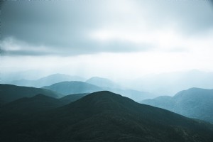 Una colina verde oscuro contra el cielo ahumado Foto