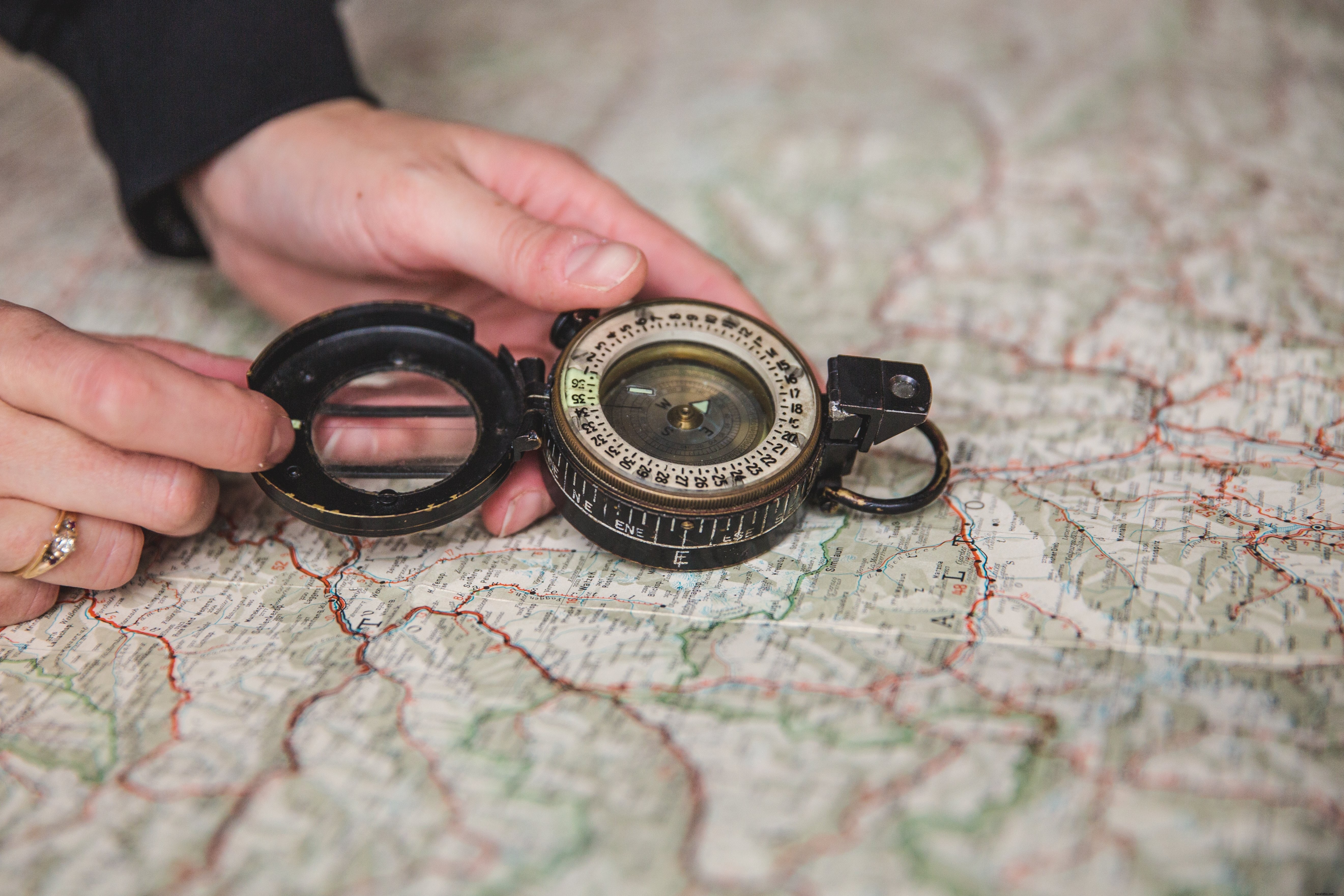 Jovem segurando a bússola sobre a foto do mapa