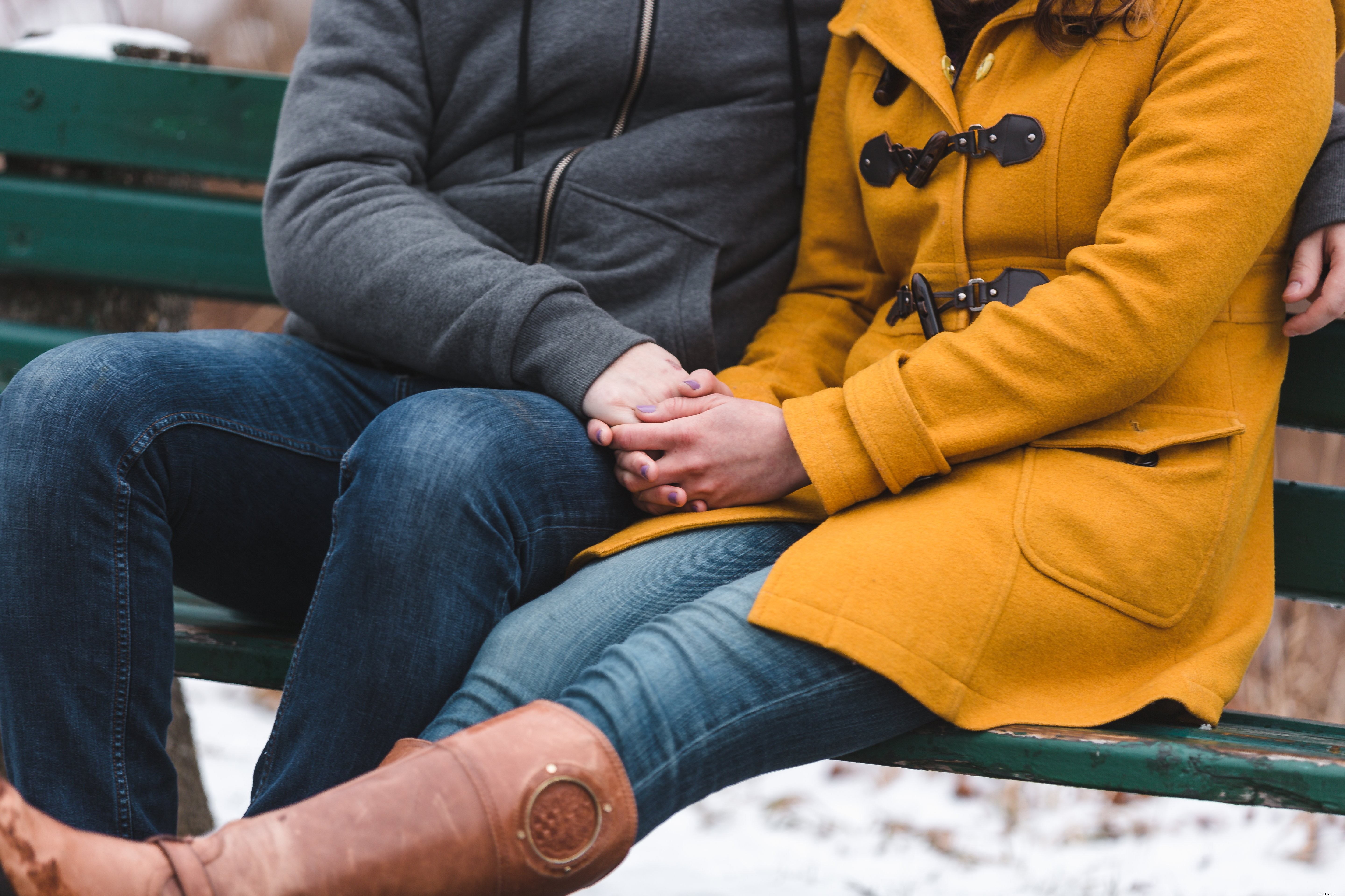 Un couple se blottit pour se réchauffer sur une photo de banc