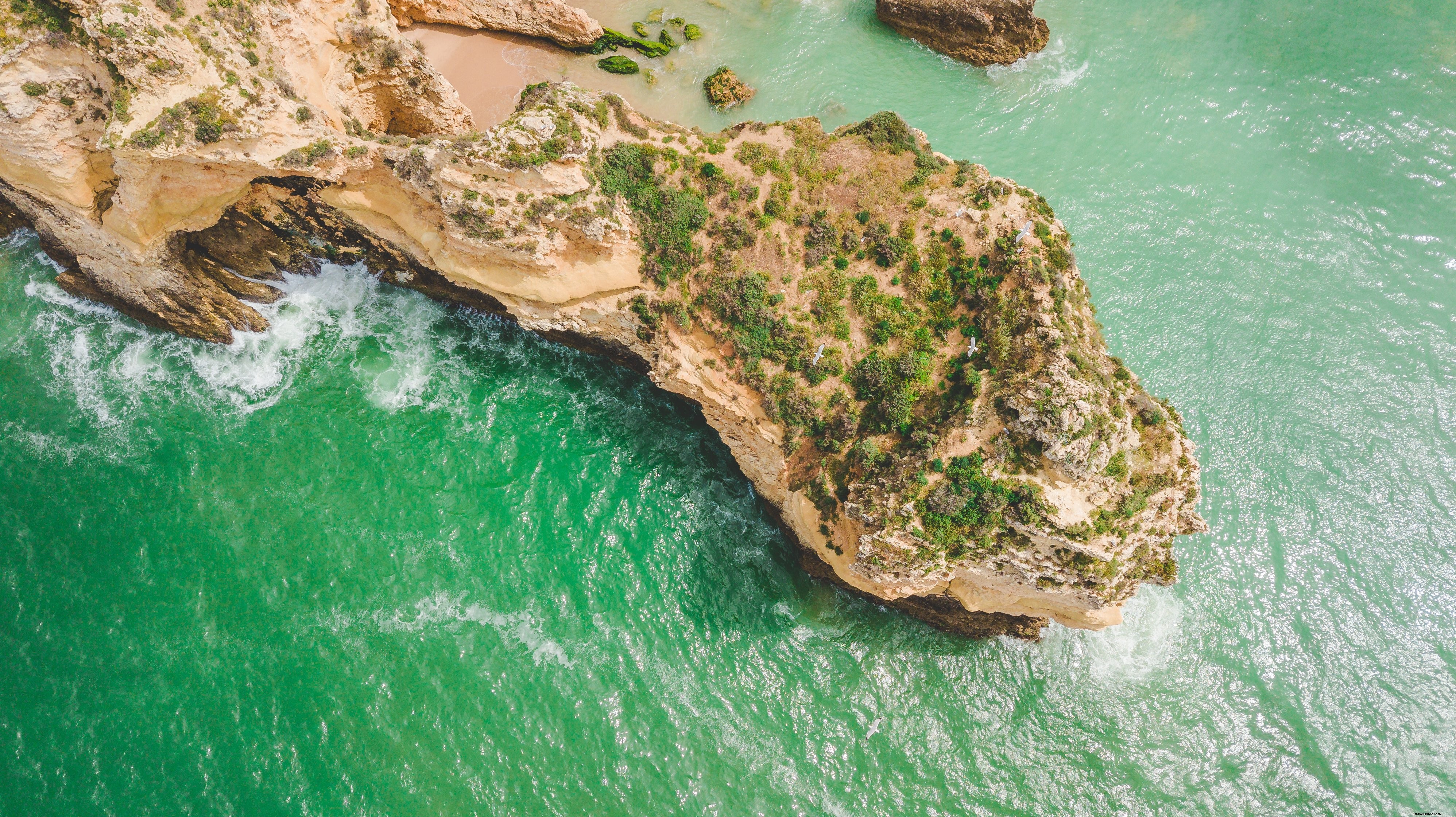 Foto do oceano encontra-se com o litoral rochoso