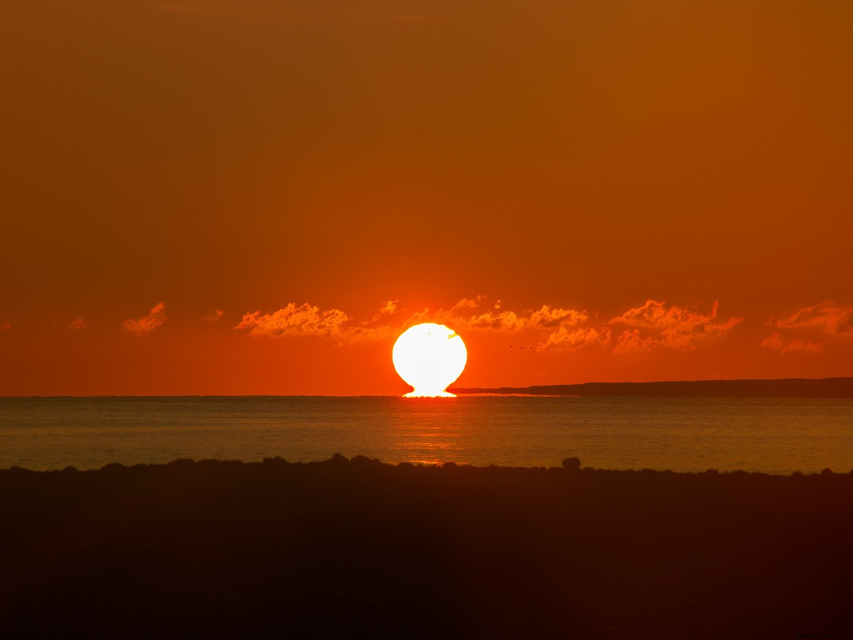 地平線の真っ赤な夕日写真