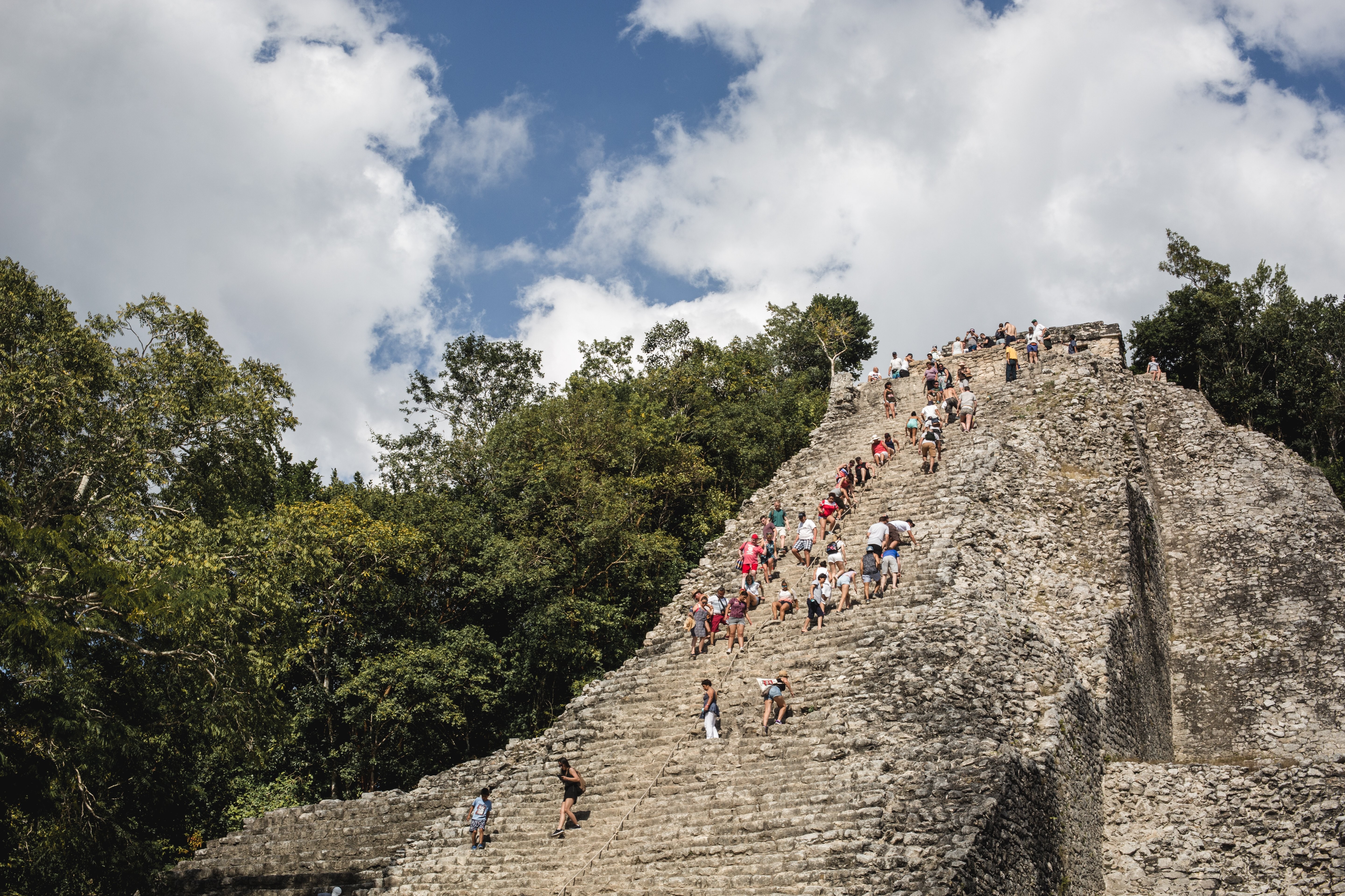 観光客がメキシコの遺跡を登る写真