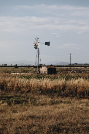 Pequeño edificio rural con foto de molino de viento
