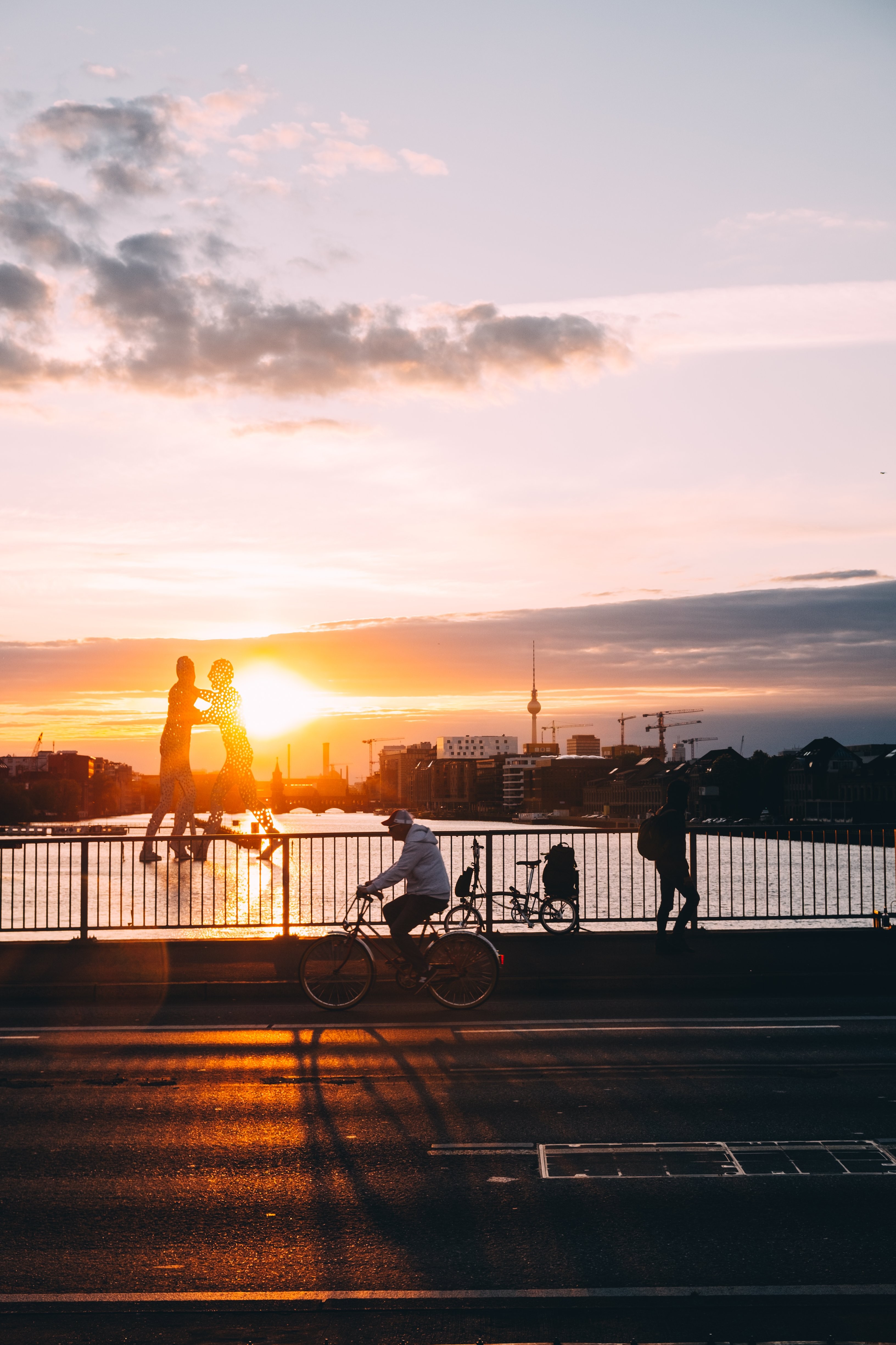 Puesta de sol brilla sobre el agua junto a una foto de un puente