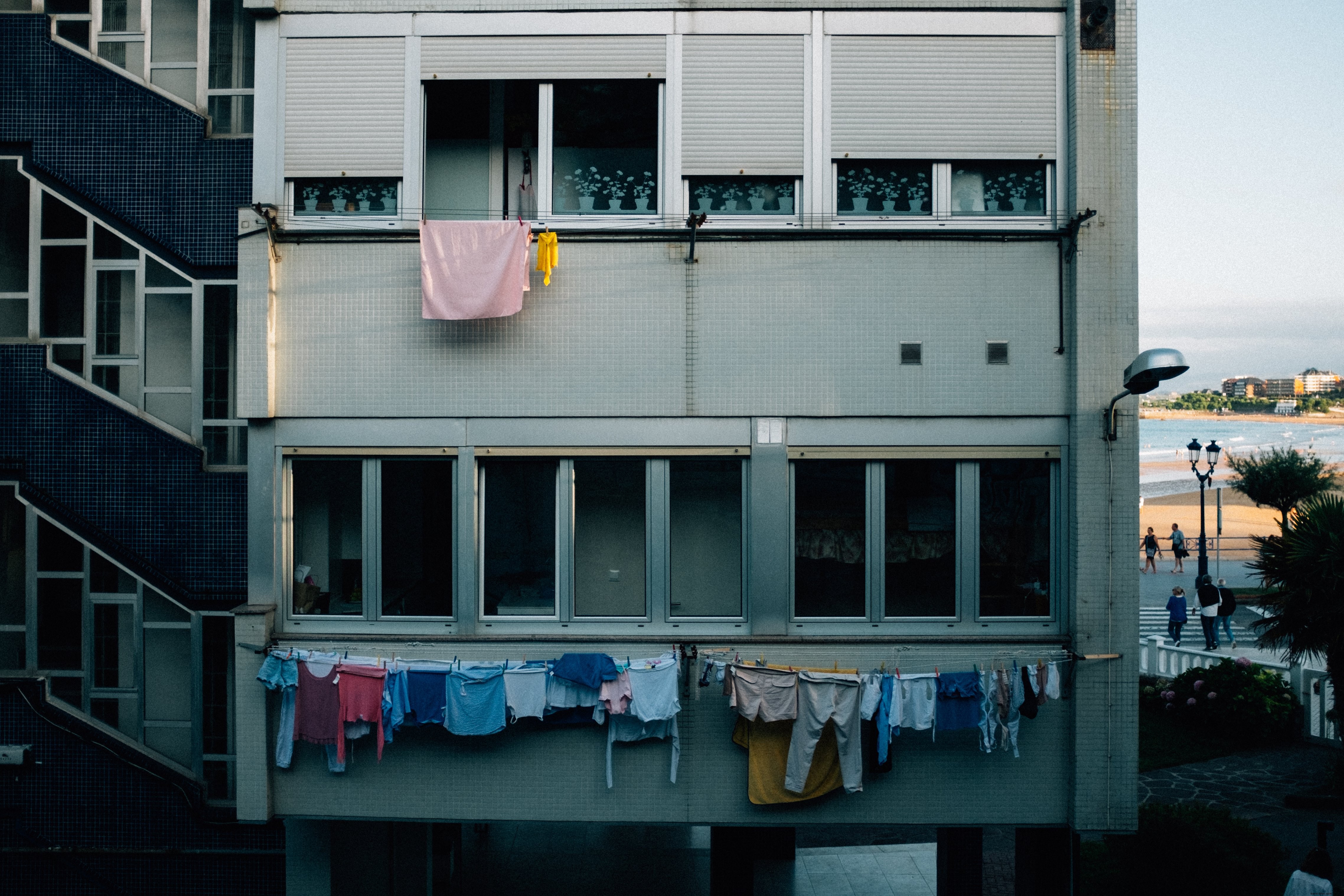 Foto de la cara gris de un bloque de apartamentos envuelto en líneas de ropa