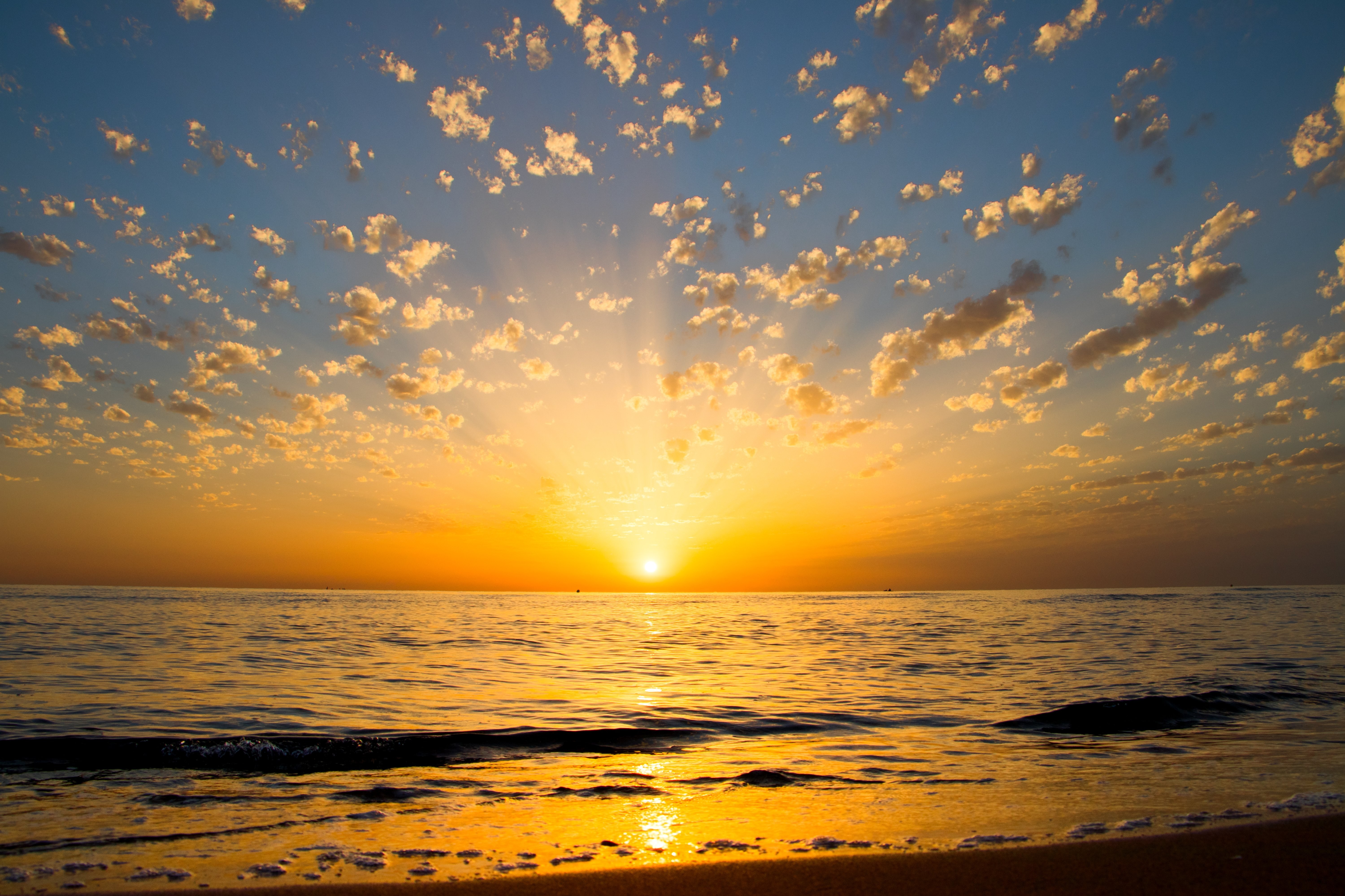 Foto de reflexos amarelos do nascer do sol sobre a água
