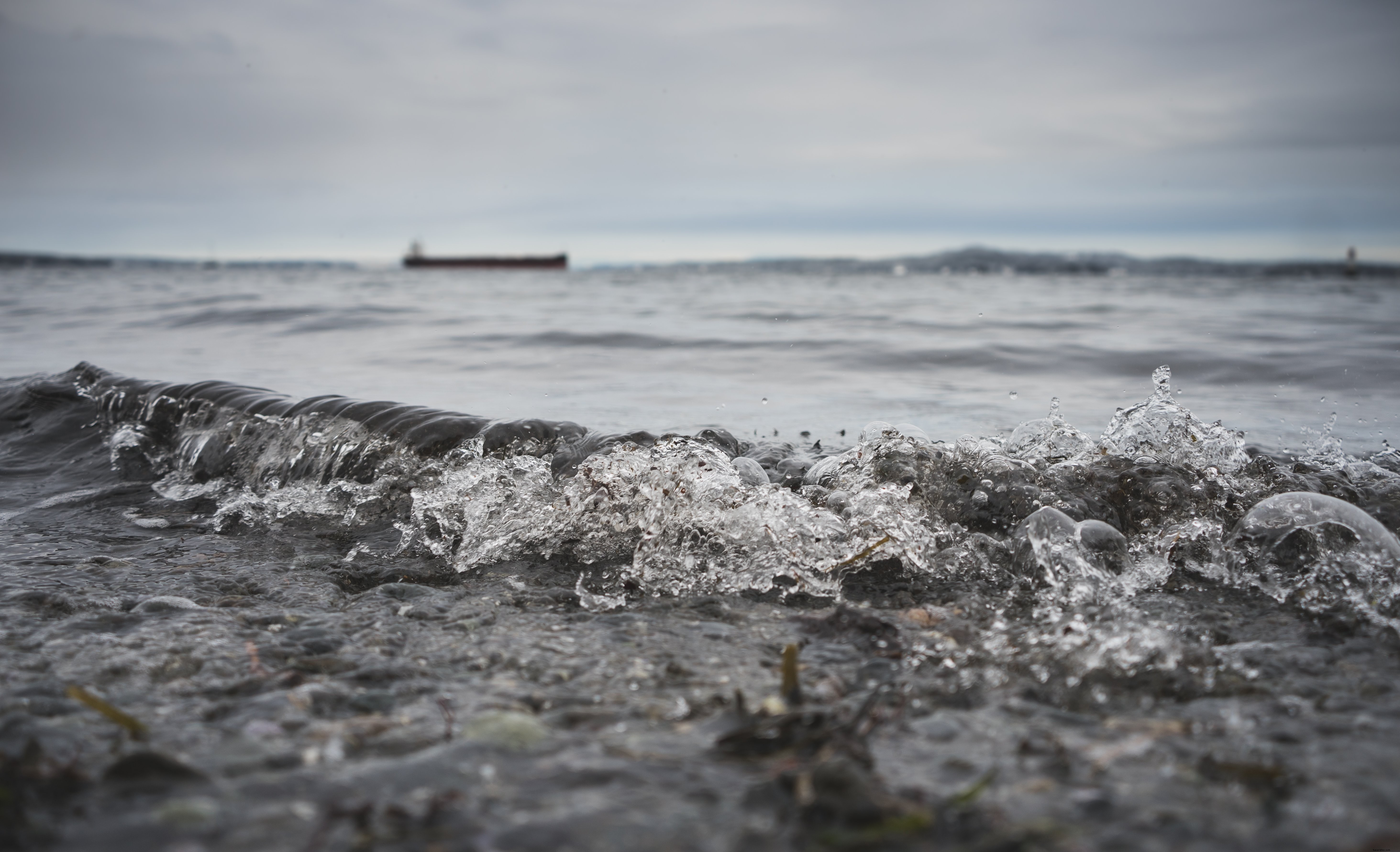 L acqua rotola a riva in una giornata nuvolosa foto
