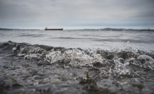 L acqua rotola a riva in una giornata nuvolosa foto