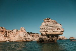 Una sola pila rocosa emerge de Blue Waters Photo