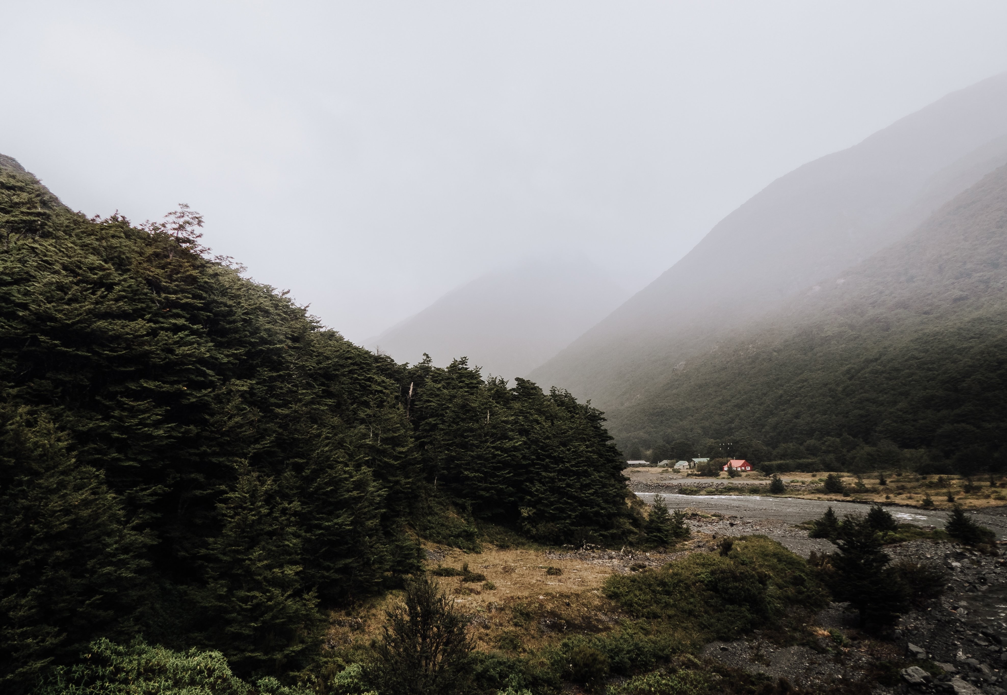 Foto del valle de la montaña brumosa y un grupo de cabañas en el bosque