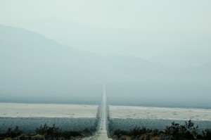 霧深い山の下を運転する写真