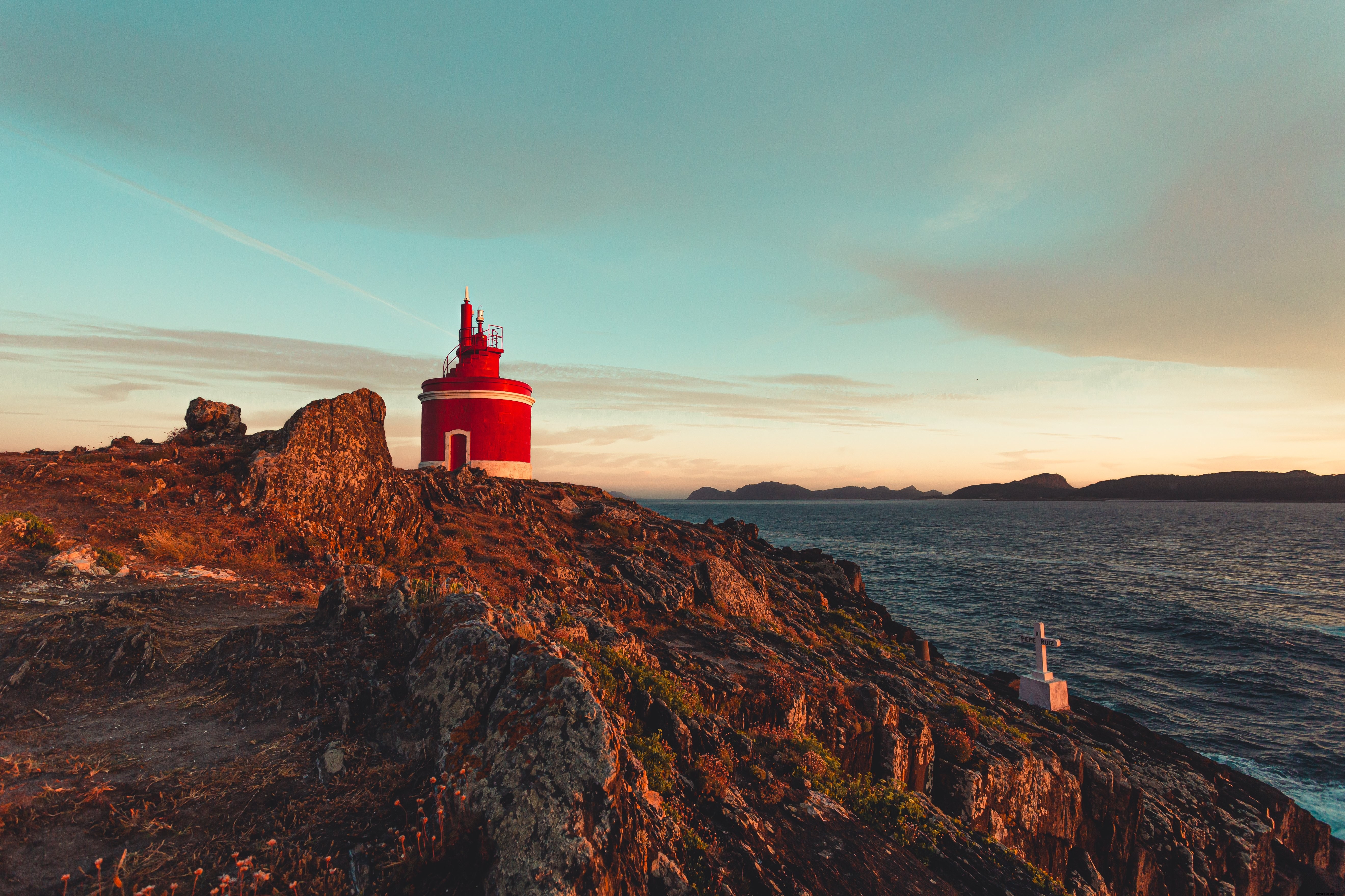 Piccolo faro rosso tra le rocce foto