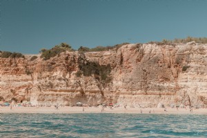 天気の石灰岩の断崖の下の砂浜の長いストレッチ写真